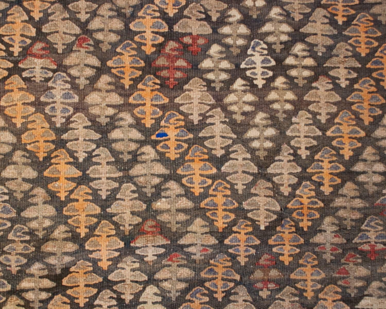 An early 20th century Persian Qazvin Kilim runner with a beautiful all-over tree-of-life pattern, with a subtle zigzag stripe woven with a pale yellow and red naturally dyed wool. The borer is comprised of a yellow geometric stripe flanked by two