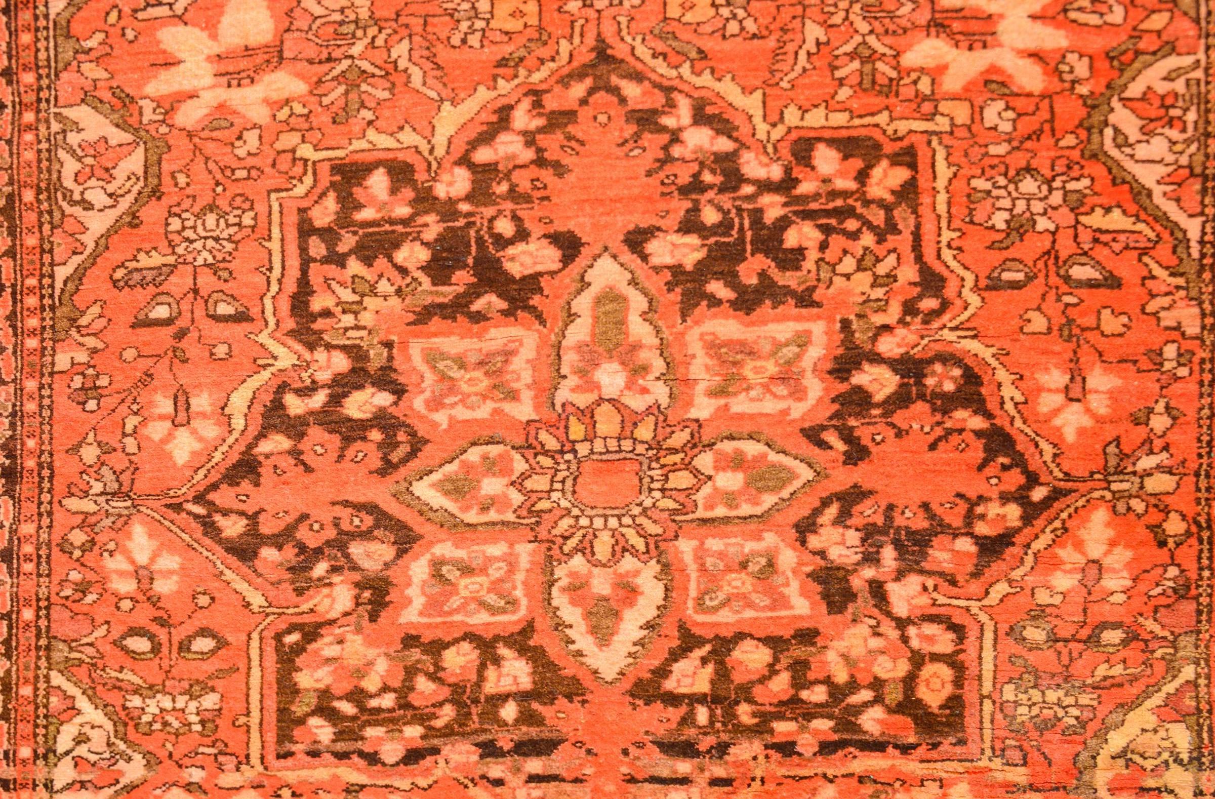 A unique early 20th century Persian Sarouk Farahan rug with an incredible predominently crimson color way. There is a large eight-lobed medallion on a field of Hensley woven flowering vines. The border is complemeary with a large-scale floral motif.