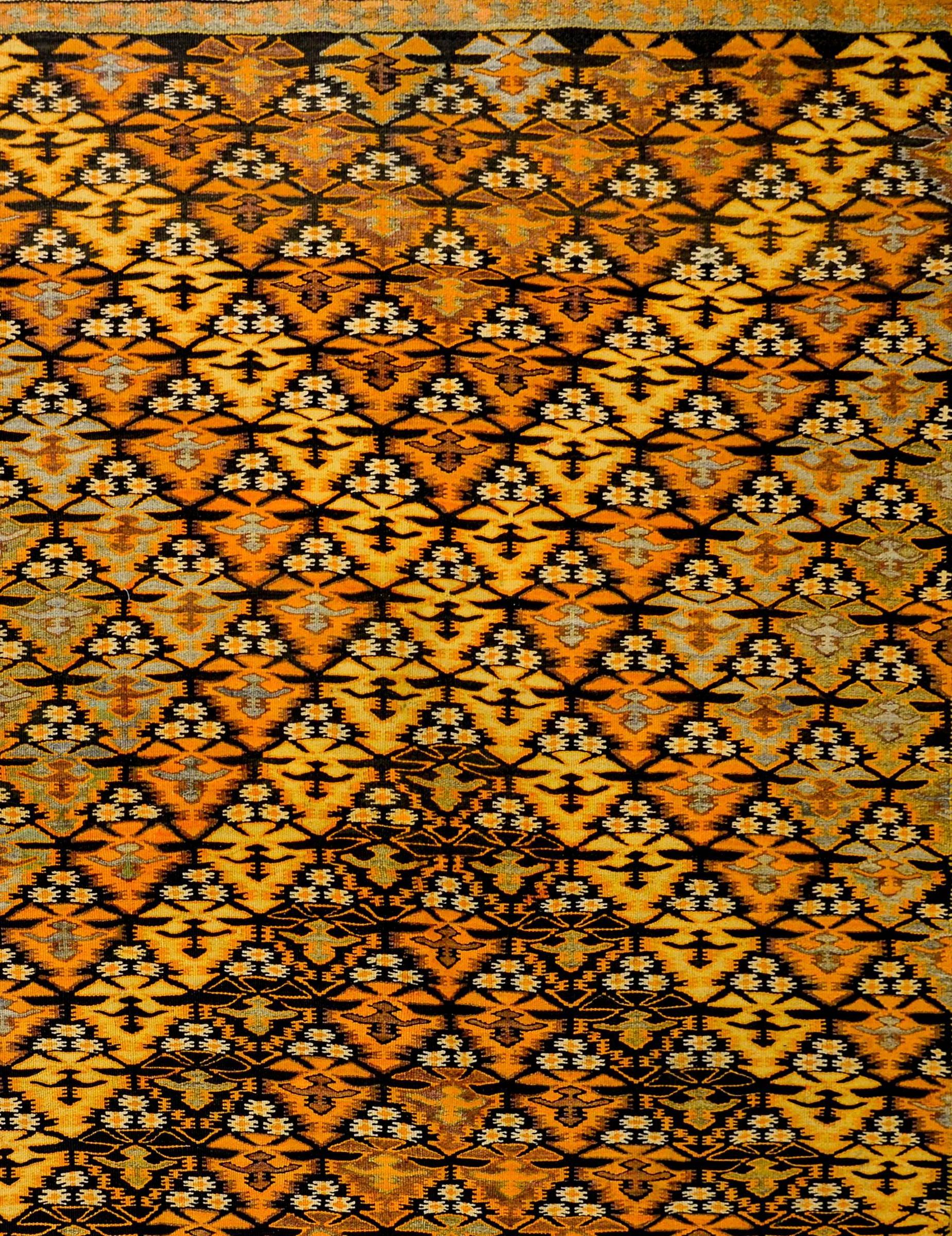 An amazing mid-20th century Persian Qazvin Kilim rug with an all-over tree-of-life pattern woven in such a way that a diamond pattern of orange, lilac and natural wool colored trees is created. The border is complex, with three distinct geometric