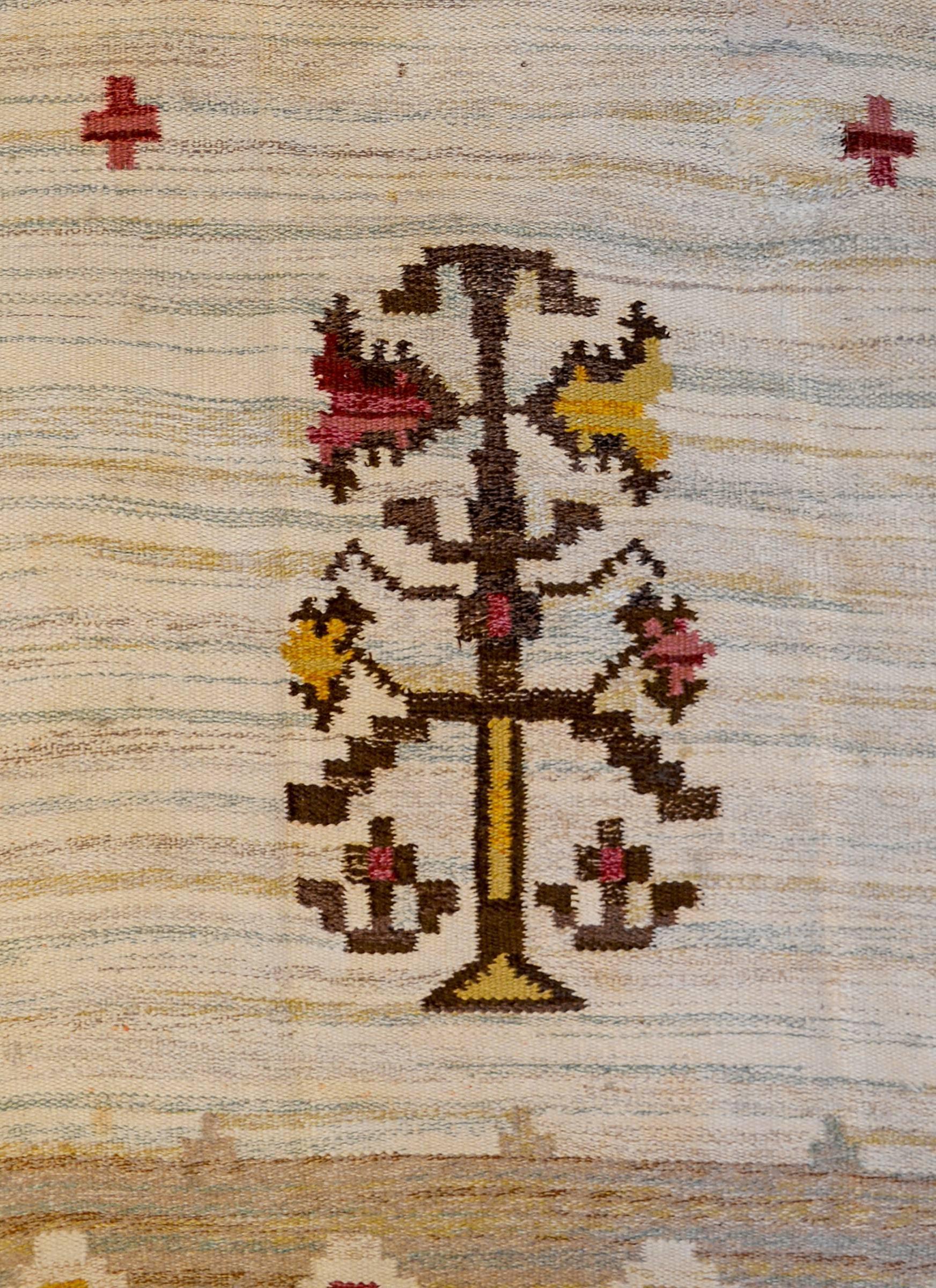 A wonderful vintage Swedish flat-weave Kilim with two mirrored stylized trees-of-life amidst a field of stylized flowers. The border is complementary with repeated diamonds with alternating crimson and gold square centres.