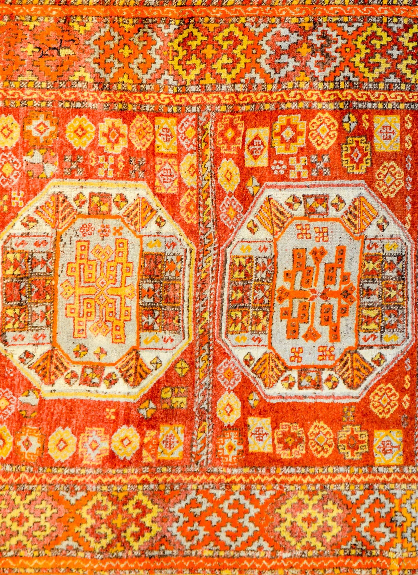 A wonderful vintage Turkish Anatolian rug with an incredible tribal pattern of hexagonal medallions woven in brilliant crimson, gold, orange, and white vegetable dyed wool, surrounded by similarly patterned and colored borders.