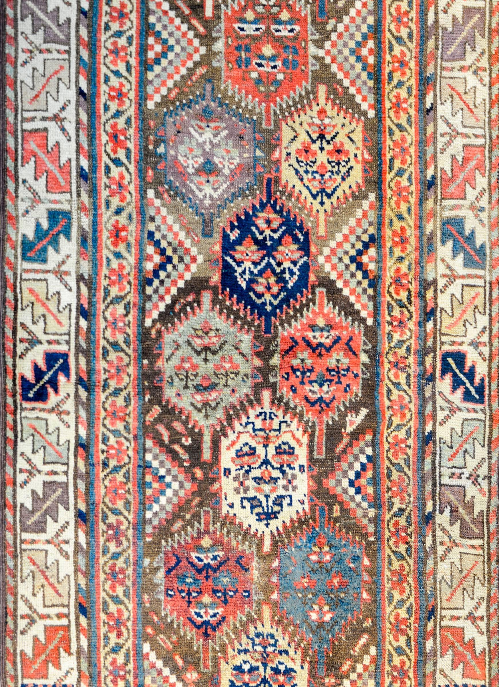 A wonderful early 20th century Persian Qasgqai runner with multiple multicolored hexagonal medallions, each with stylized trees-of-life on a brown background flanked. The border is comprised of three distinct patterns, the inner being a floral