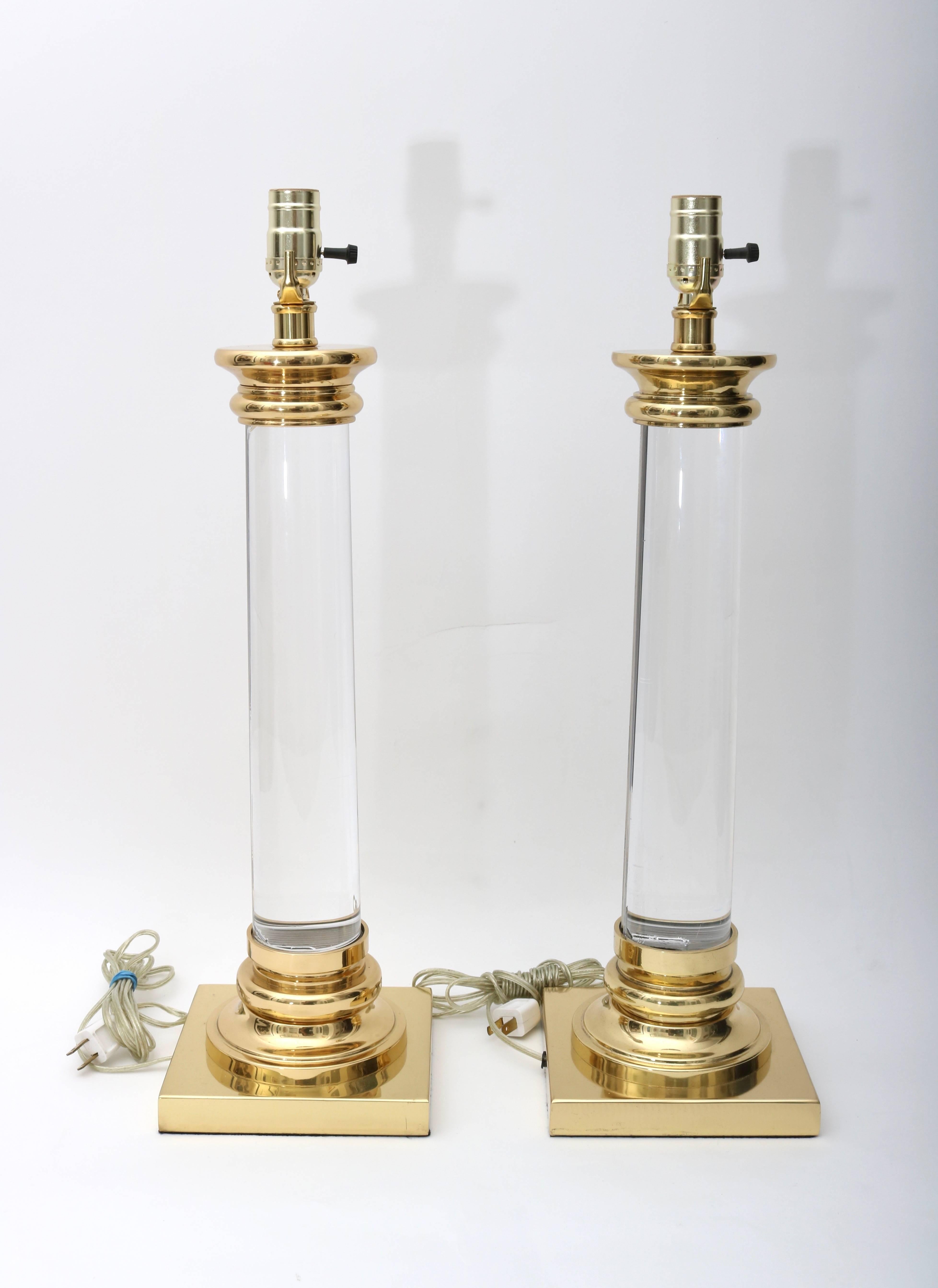 This pair of table lamps are very much in the style of pieces created by Karl Springer in the 1980s. The clear Lucite columns and polished brass give them a sense of lightness and yet a strong presence.

Note: They have been recently