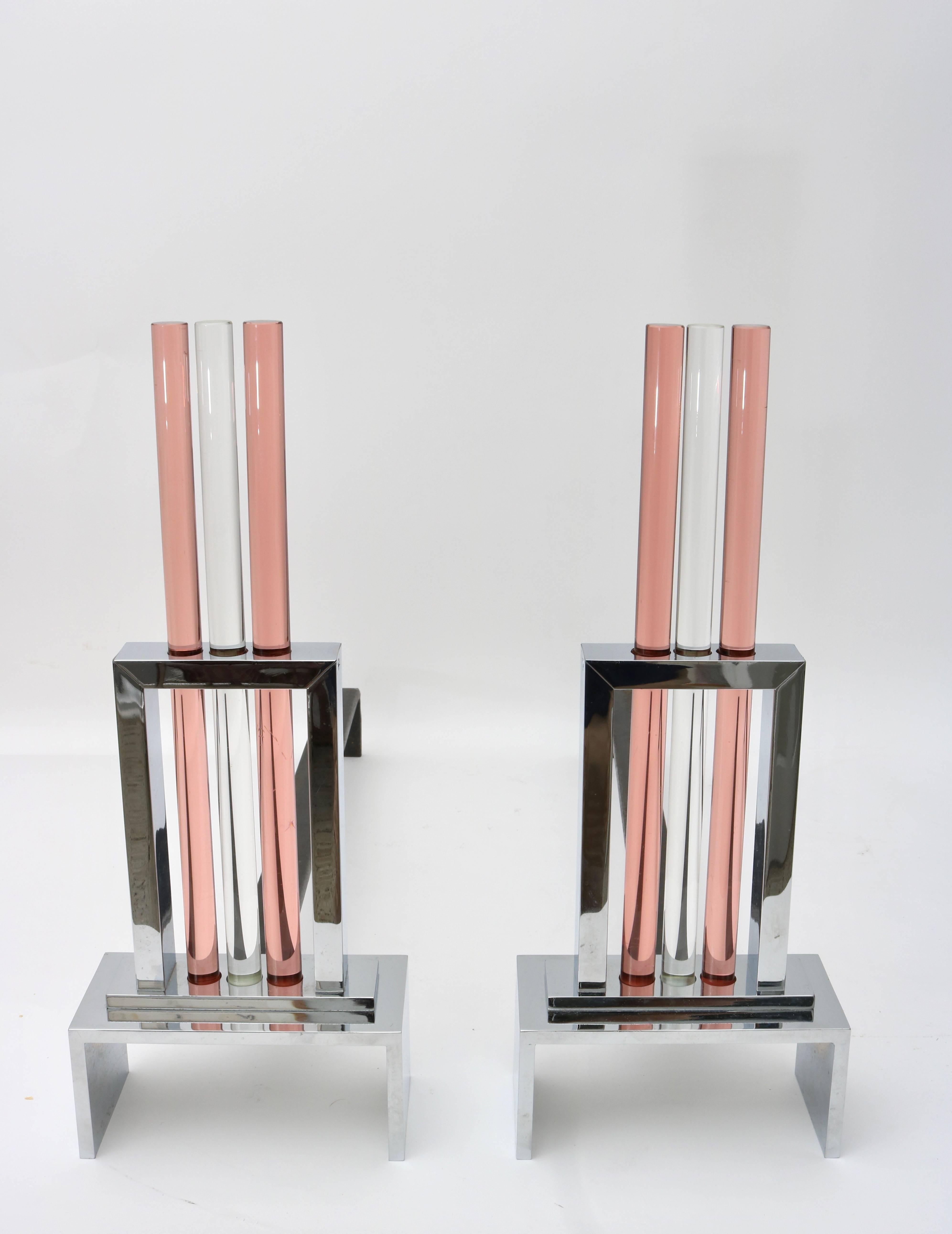 This stylish set of andirons capture the height of the Art Deco period with their architectural look of skyscrapers glistening in the sun. The glass rods are in clear and a rose-gold coloration which complement the polished chrome beautifully.

