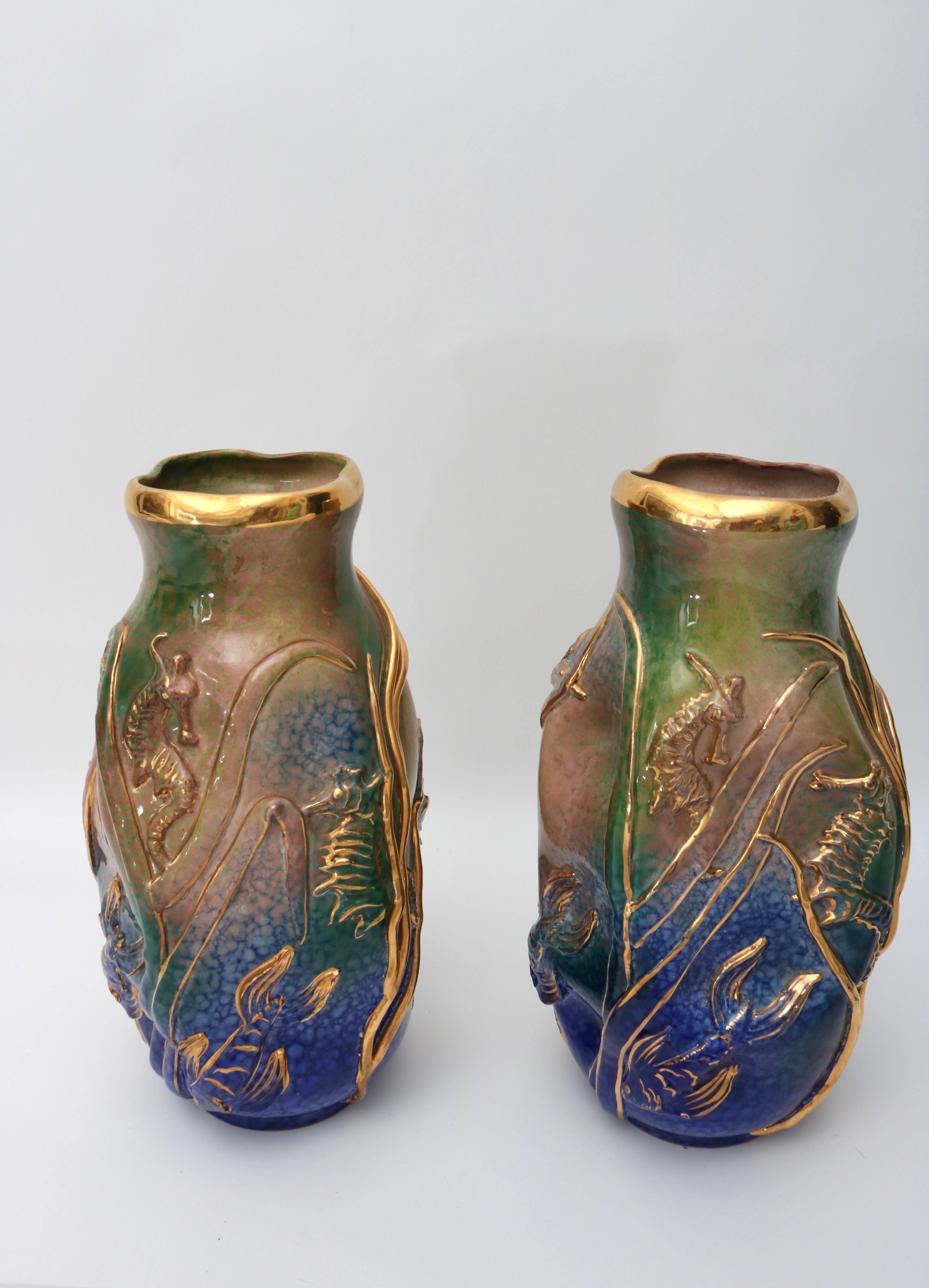 This stylish pair of vases are very much in the style of pieces created by Gio Ponti. They were made in Italy in the late 1950s to the 1960s and sold by M. Fusco in New York city. They are glazed terracotta with embellished with sea grass, seahorses