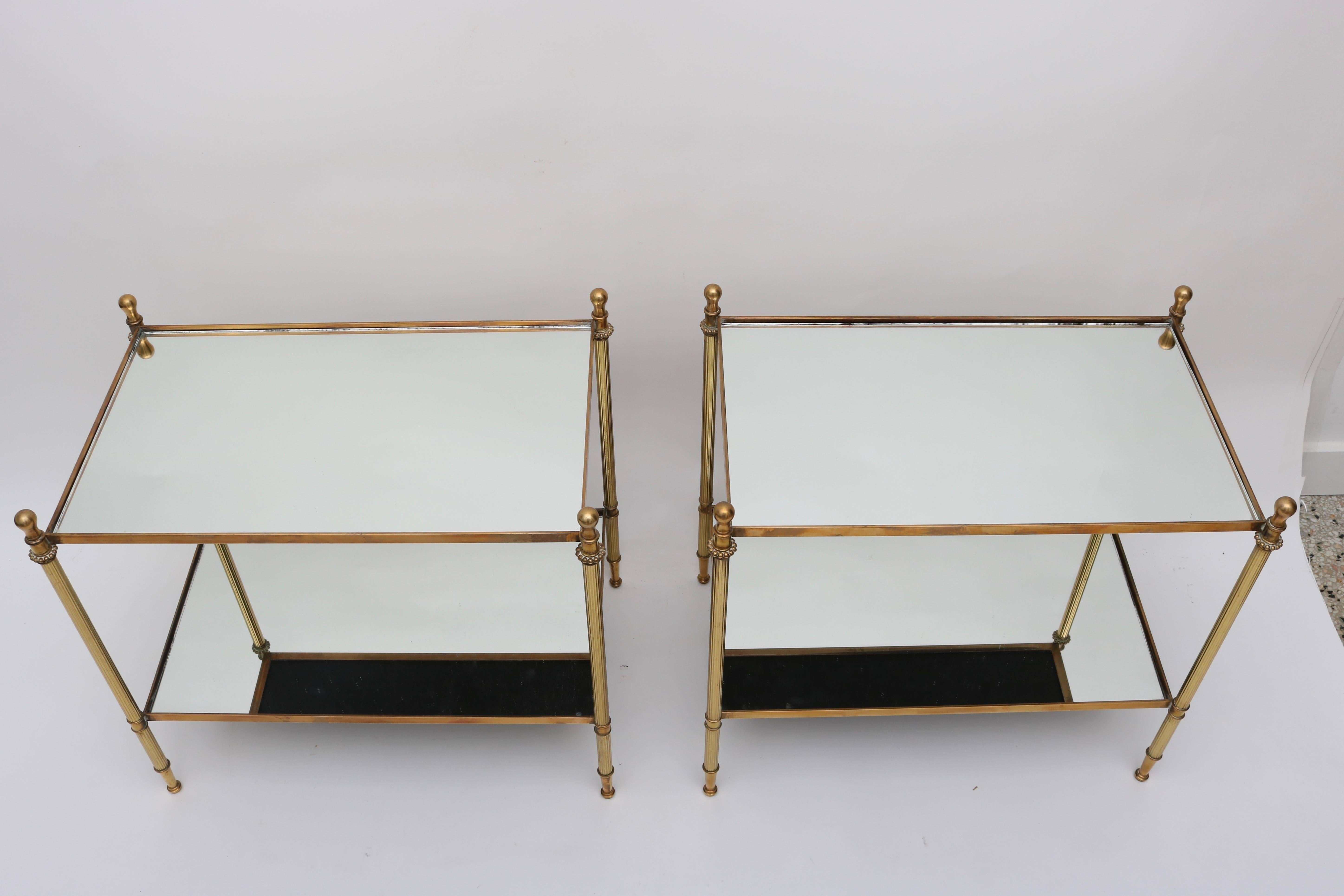 This stylish pair of side tables are very much in the style of pieces created by Maison Jansen. They are fabricated of brass and glass with fluted legs, and stylized fob finials.

For best net trade price or additional questions regarding this