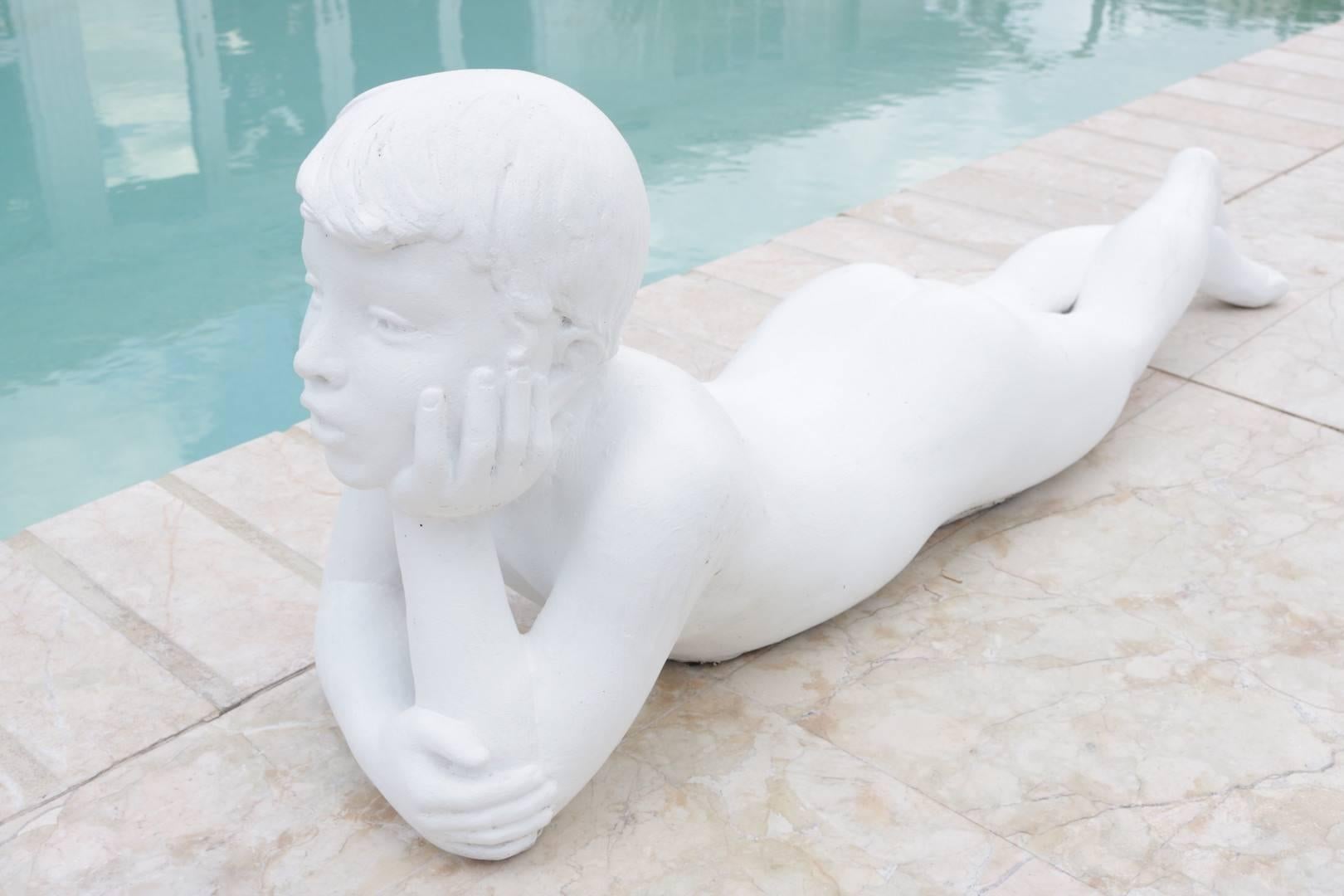 This charming sculpture of a young boy reclining was purchased from a Miami, Florida estate.   The piece has an Art Deco sense to it as well as a clean mid-century feeling.  The piece has a wonderful innocence to the days spent in childhood with