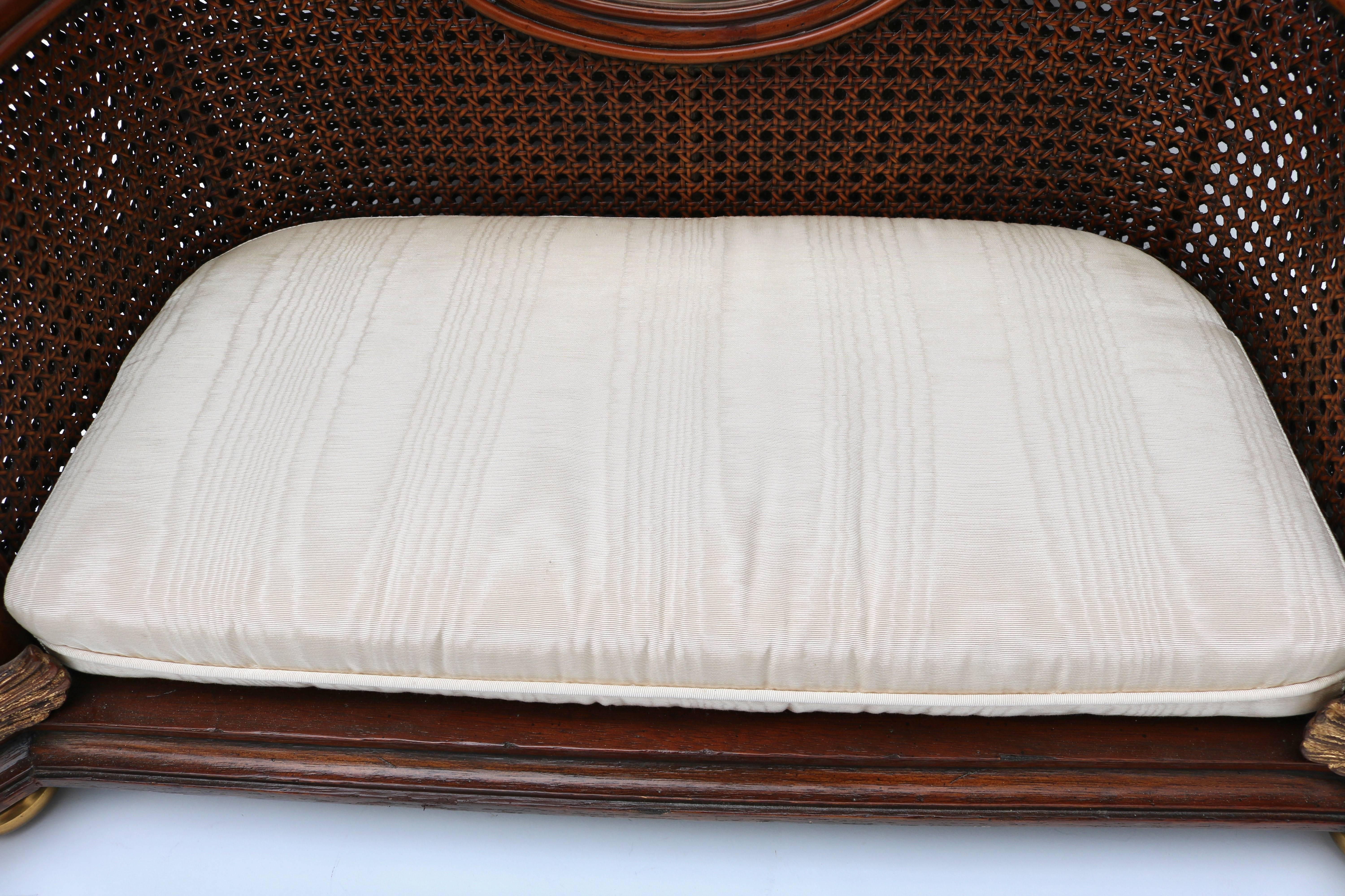 This stylish pet bed was created by the iconic firm of Maitland Smith and is in English Regency style with its mahogany wood frame, French caning and gold finished dolphins. The moire pattern fabric is in a tan coloration and works beautifully with