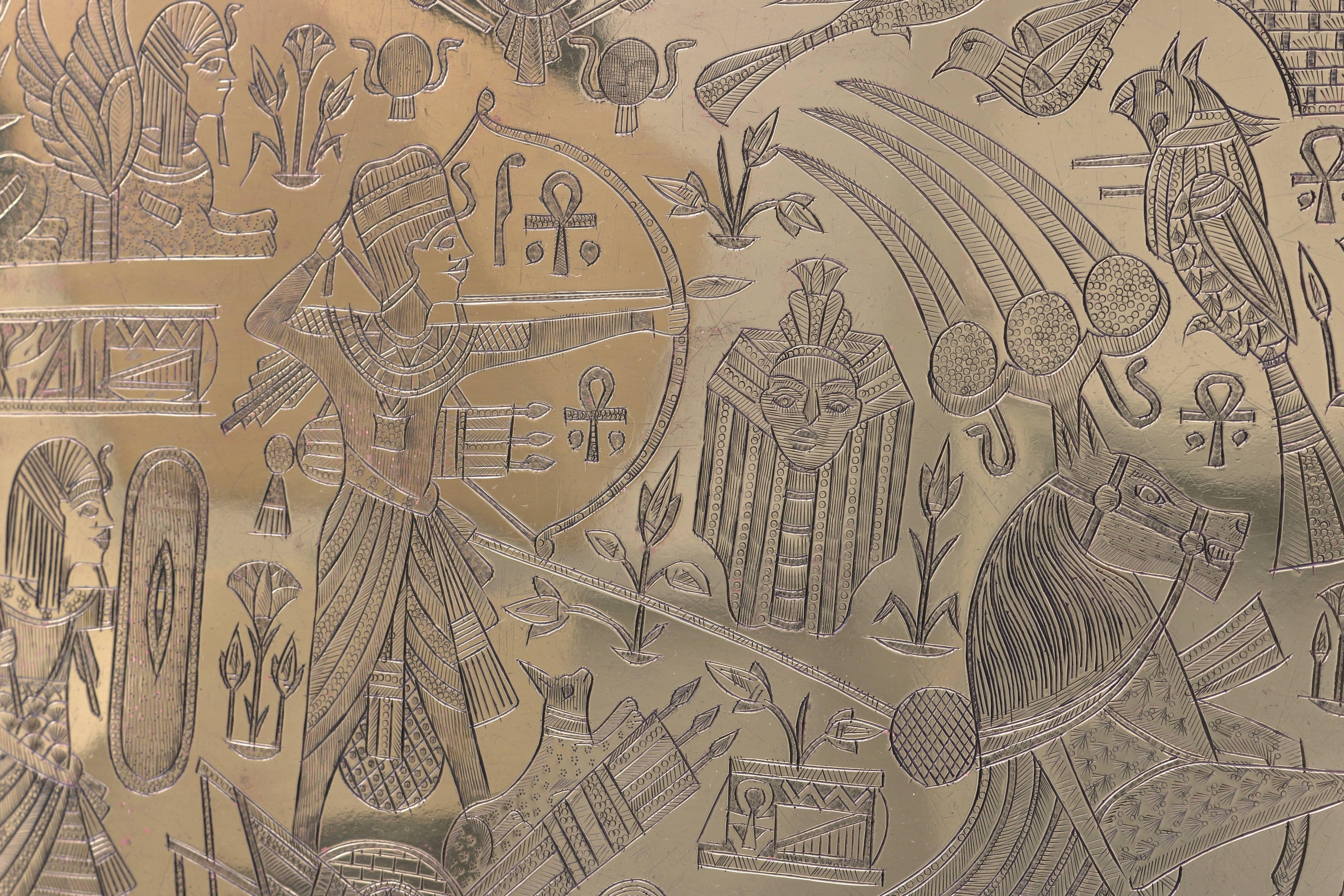 This stylish brass tray dates from the early 1920s with its motif of Art Deco stylized Egyptian figures and hieroglyphics. The piece has been professionally polished and has a clear lacquer finish. 

The piece can be used for serving and it also