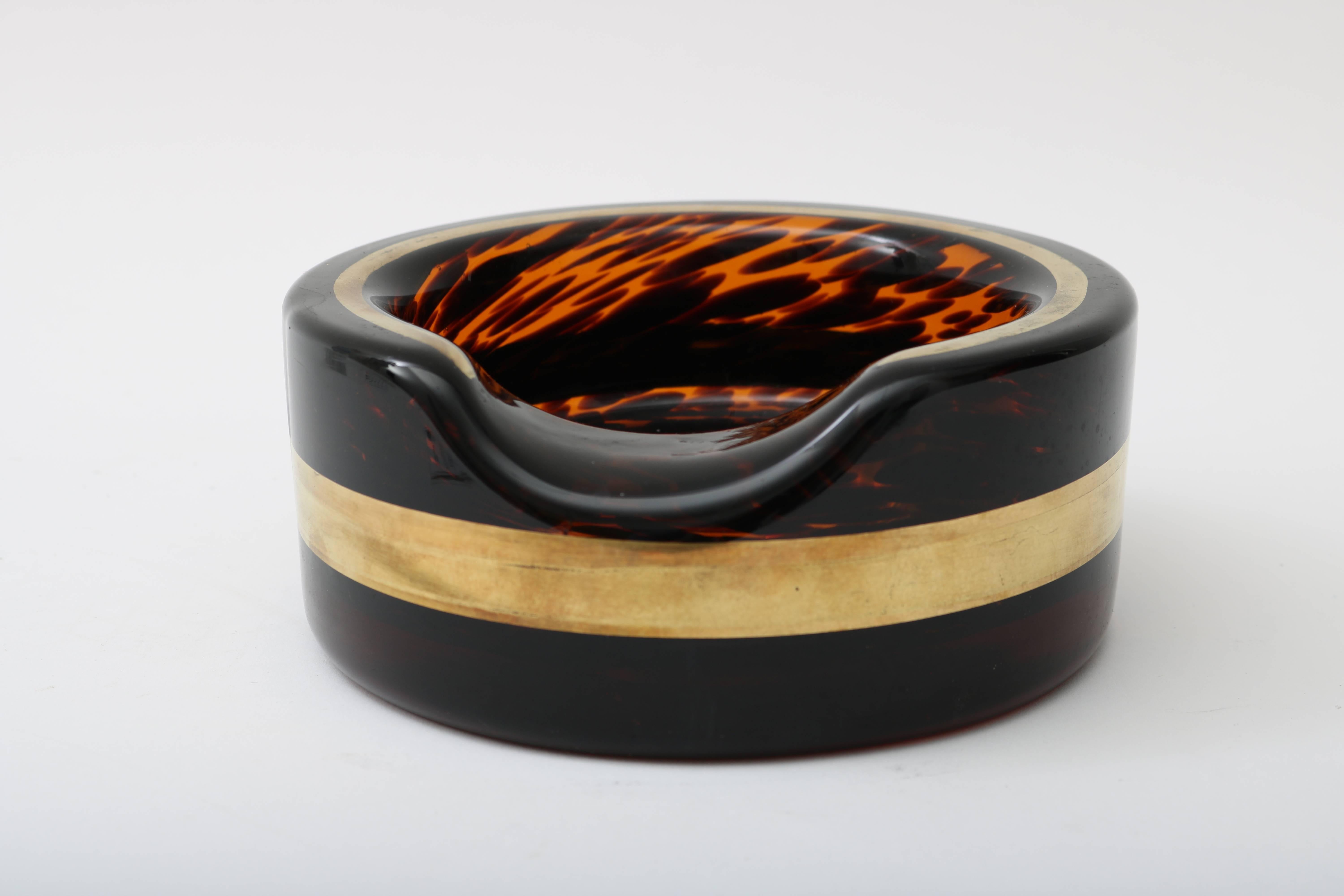 This stylish Murano glass cigar ashtray was fabricated in the 1970s and very much has the style of pieces created by Seguso for Karl Springer and Willy Rizzo. The tortoise pattern glass has a wonderful dark coloration which contrast well with the