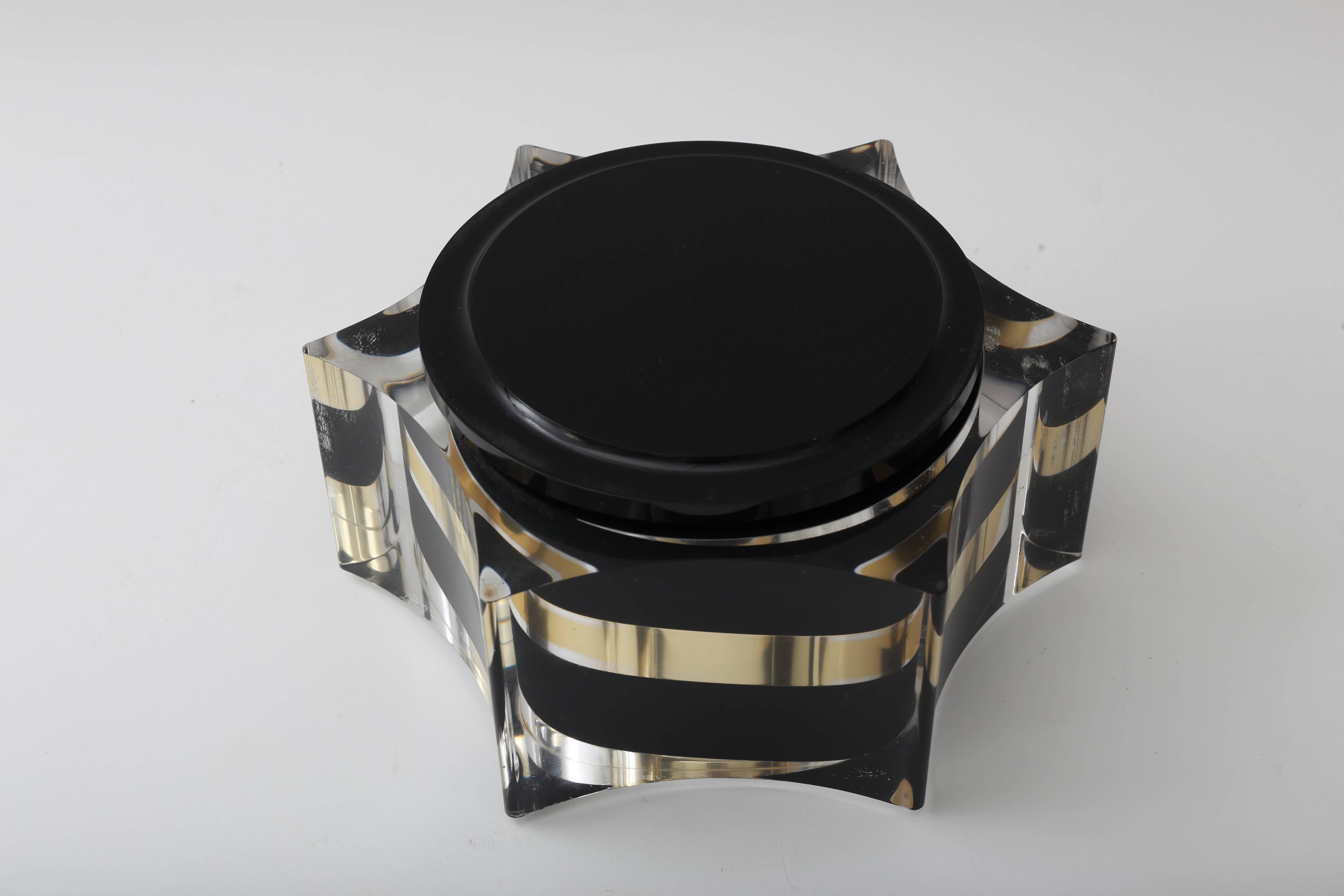 This stylish Lucite box is very much in the style of pieces created by Willy Rizzo in the 1970s with its black, gold and clear Lucite coloration. 


    