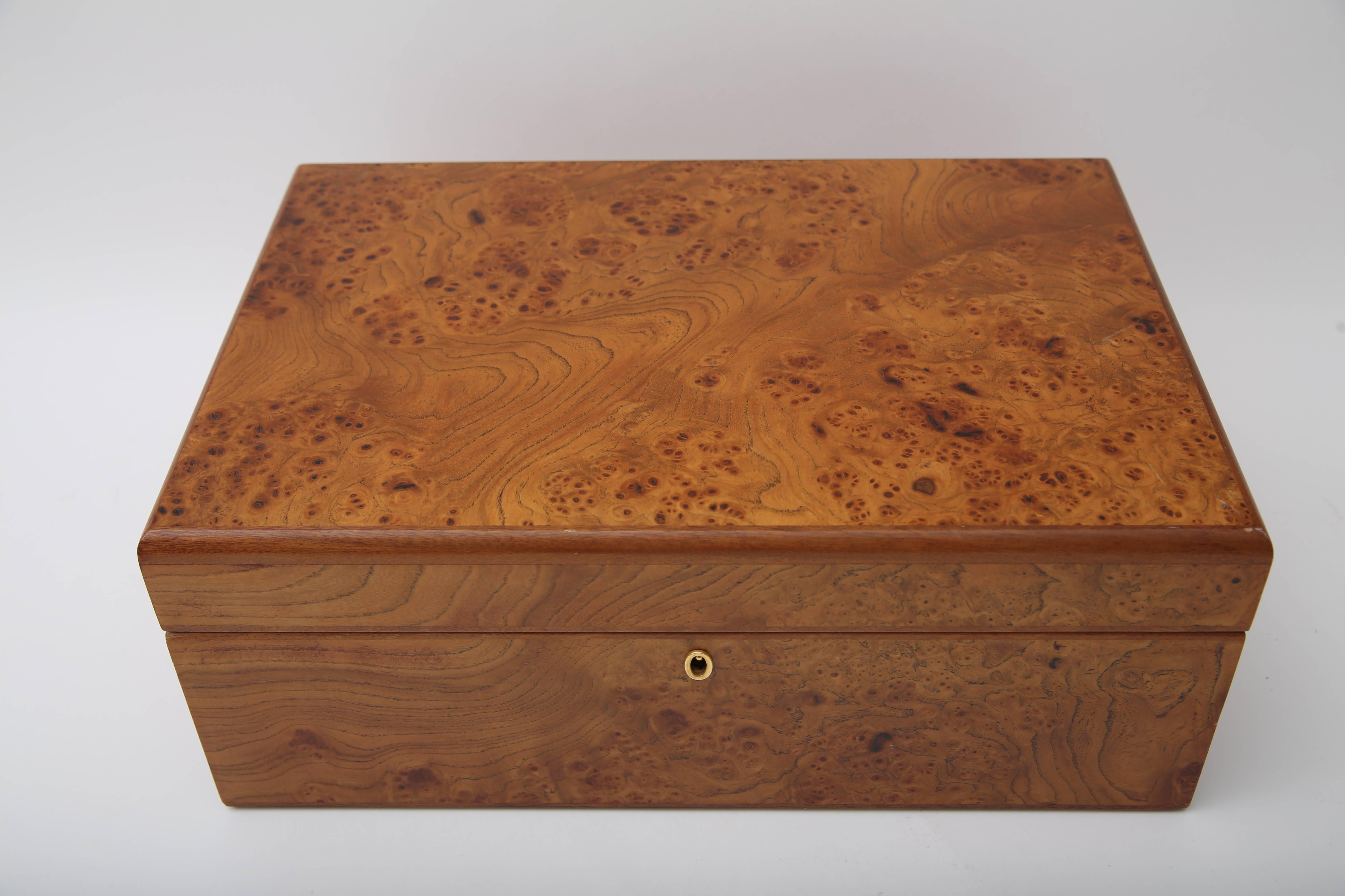 This large-scale humidor was produced by Agresti and is fabricate in a burled wood with a wonderful honey coloration and retains its original key, cigar cutter and has a removable tray.

 