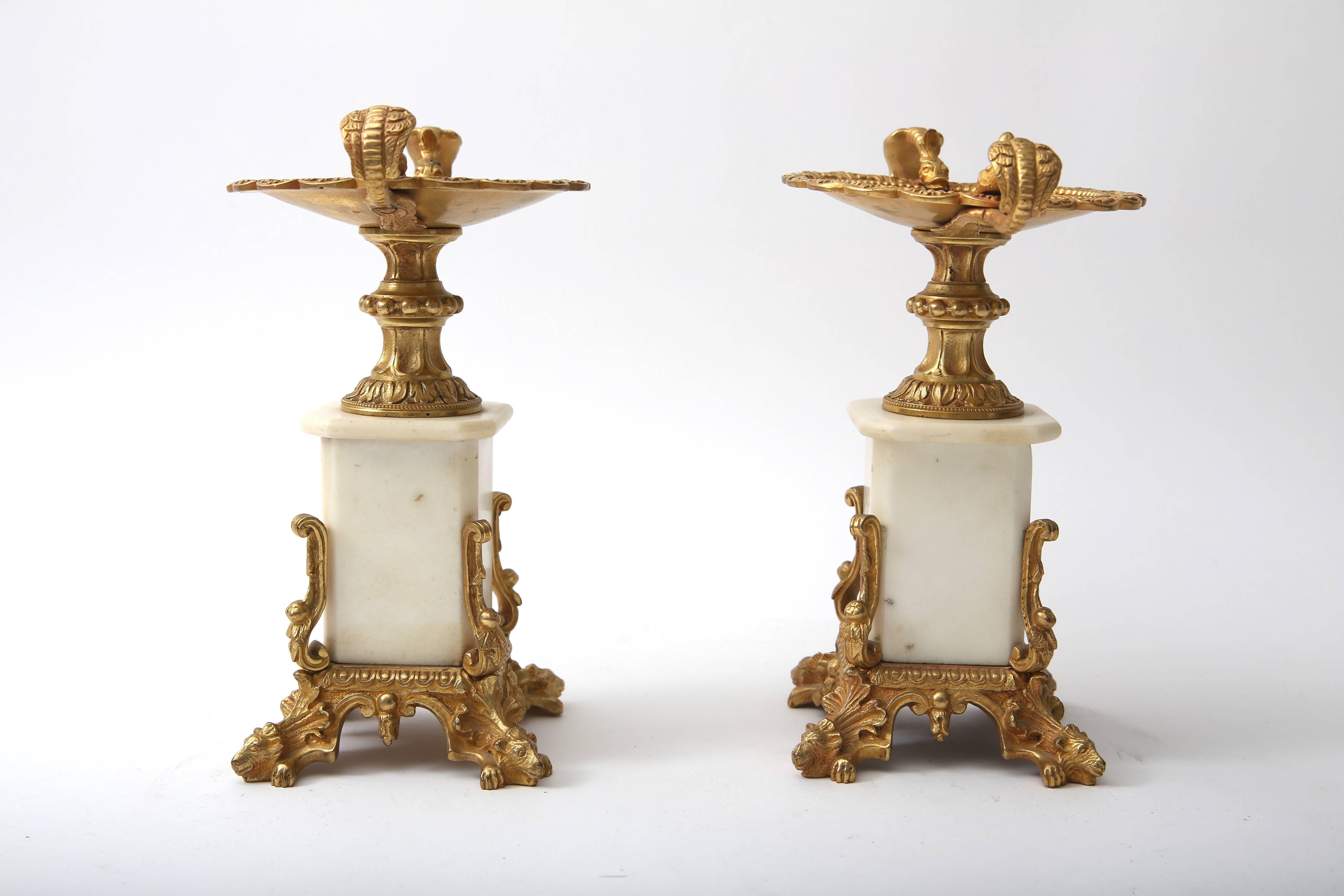 This stylish set of fireplace garnitures were recently acquired from a Palm Beach estate and are in the style of Napoleon III and date to the late 19th century.  The pieces are detailed with sea serpent/dragons and lion heads all in gilt-bronze. 