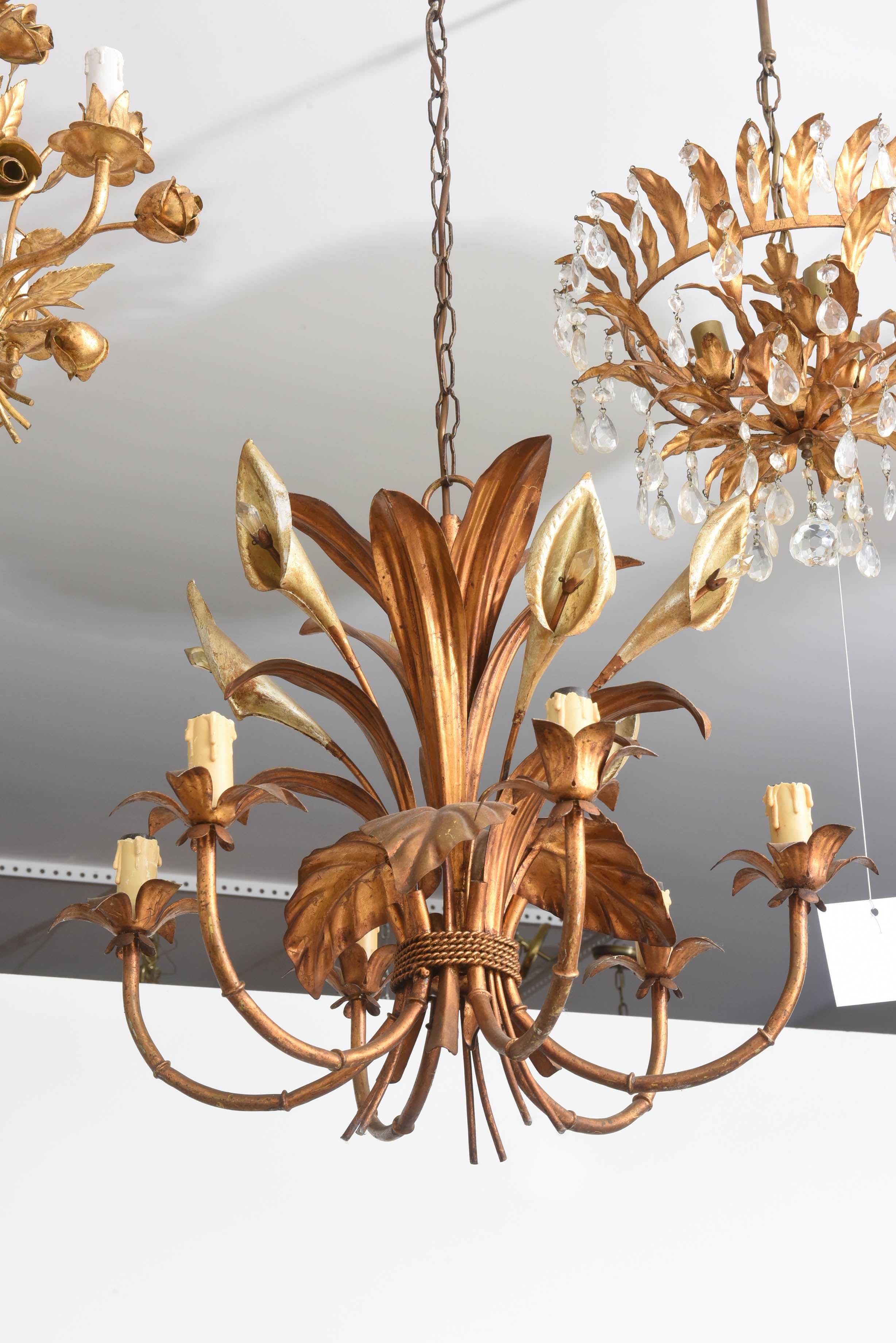 This gilt-metal six-light, faux-bamboo chandelier epitomizes the Hollywood-Regency Style.  With its Calla Lily blooms with their cut-crystal stamens and the faux-bamboo arms this piece has a graceful, glamorous and elegant presence.

The main body