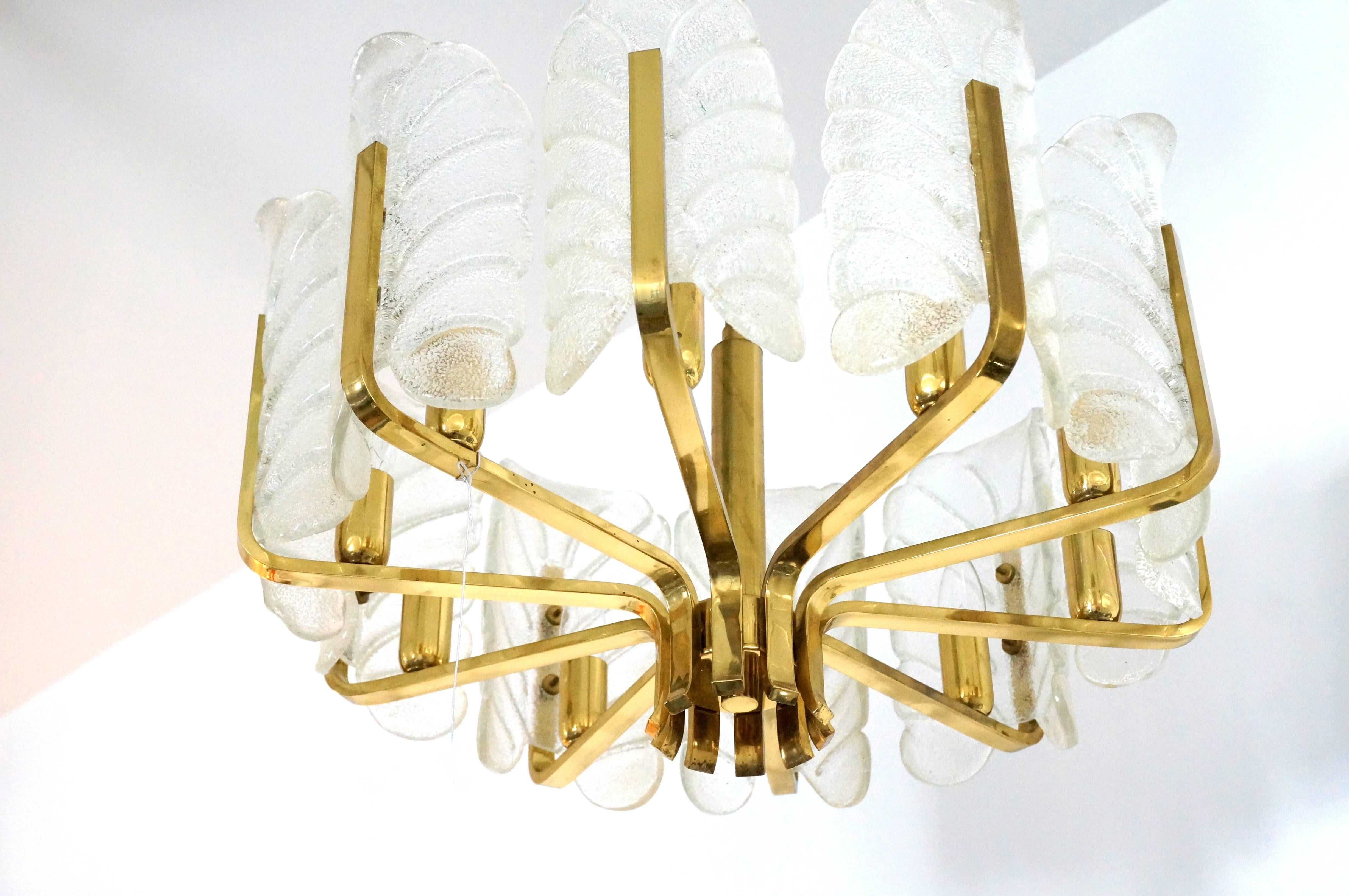 This Hollywood-Regency style chandelier was produced in the 1960s by the iconic firm of Oreffors and designed by Carl Fagerlund.  The ten stylized glass-leaf shades are in a molten clear and white coloration.  The piece has a great movement to it