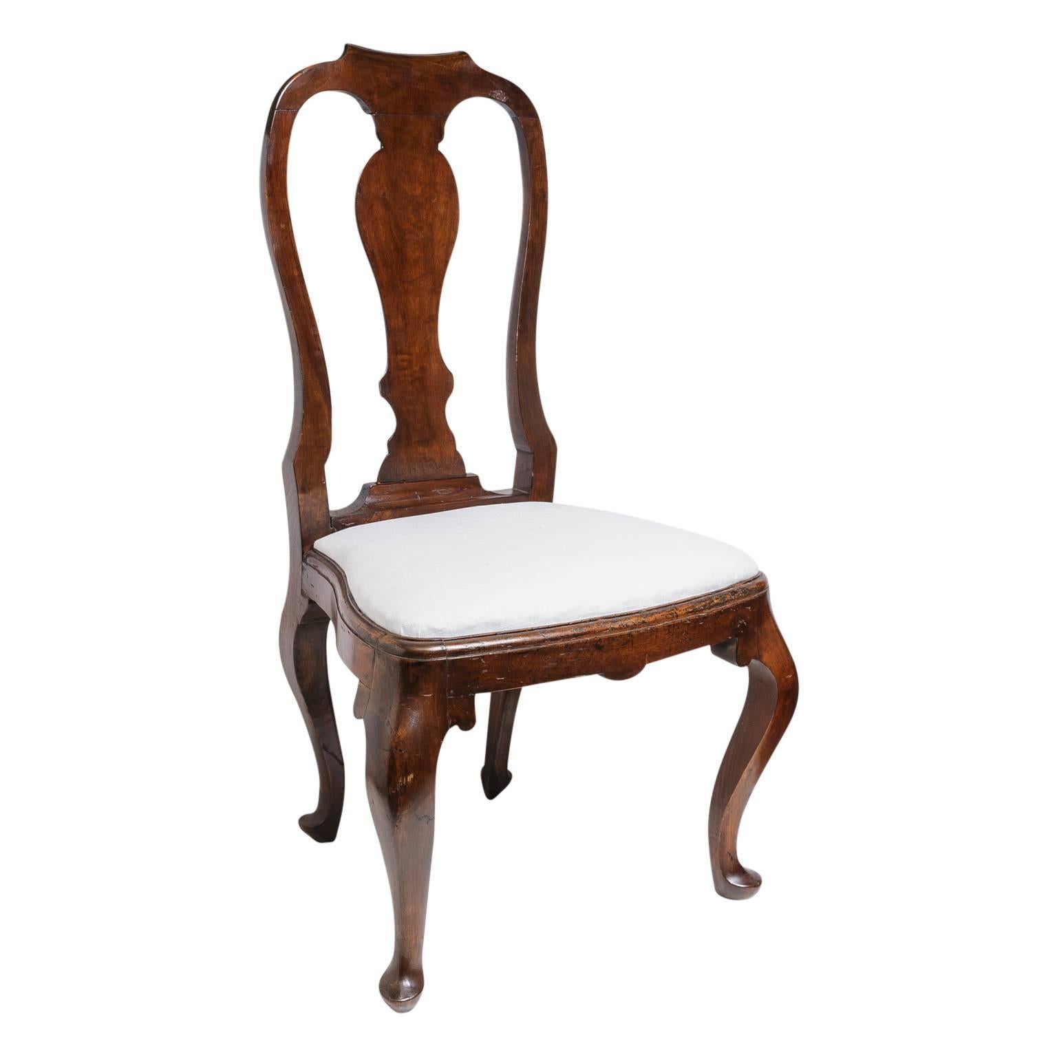 This set of four Queen Anne revival dining side chairs date from the mid to late 19th century. The frames look to be in walnut and are hand-carved with cabriolet leg, serpentine back and serpentine shaped seat. The slip seat is easily removed to