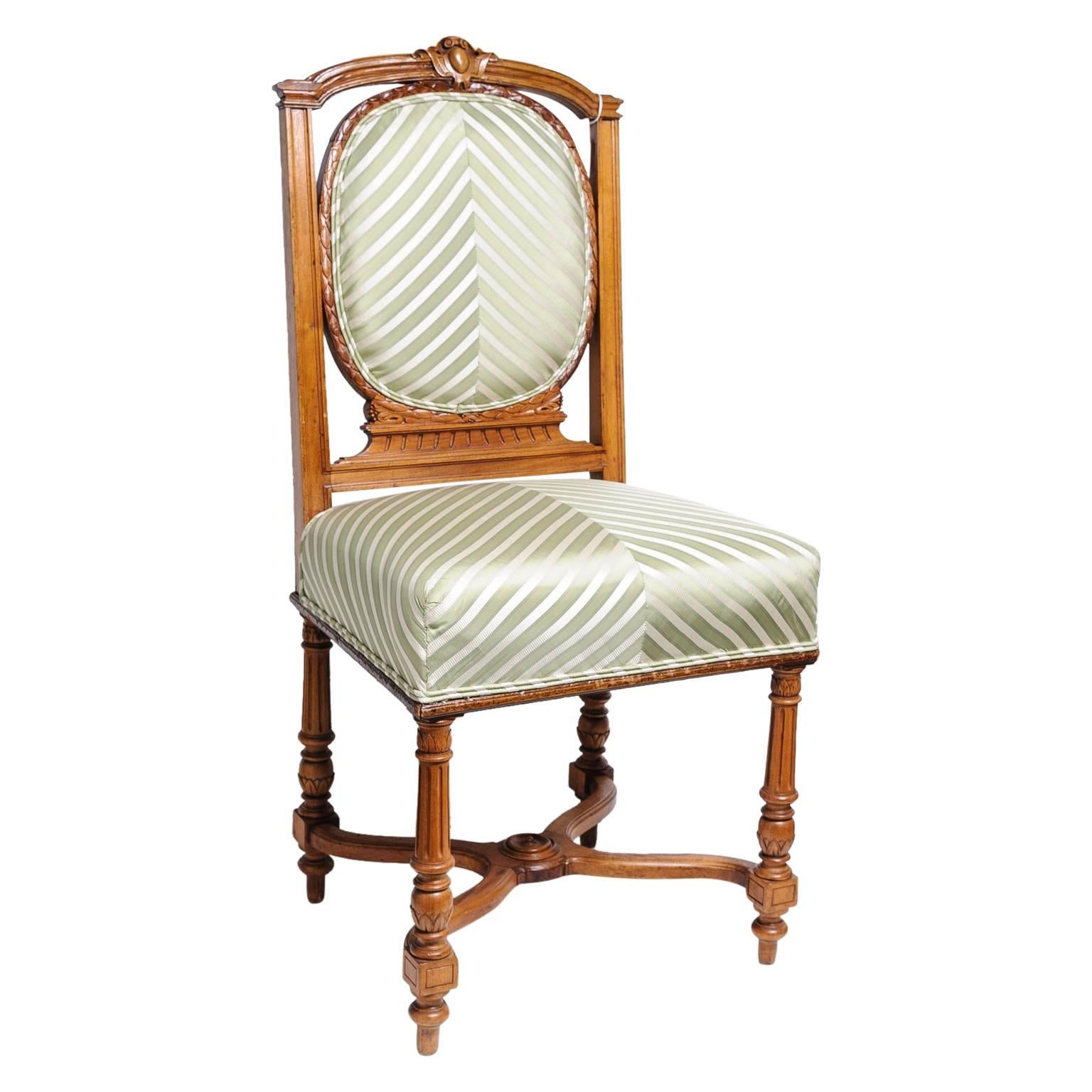 This set of six walnut wood, dining chairs date from the late 19th century and are definitely in the English, Edwardian taste. The chairs are a combination of the Louis XV and Louis XVI style with their fluted legs and serpentine cross stretcher