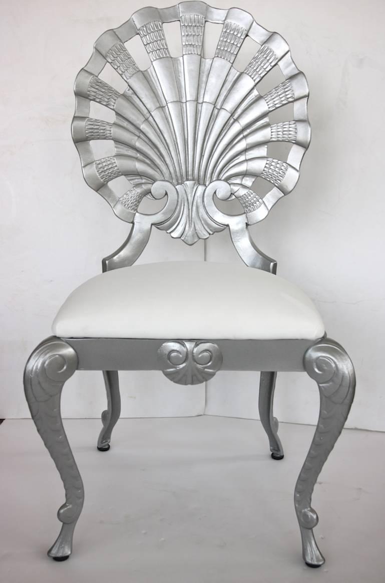 This set of four grotto style side chairs date from the 1950s-1960s and are cast aluminum which have been professionally restored with silver color automotive paint and upholstered in a white outdoor fabric.

