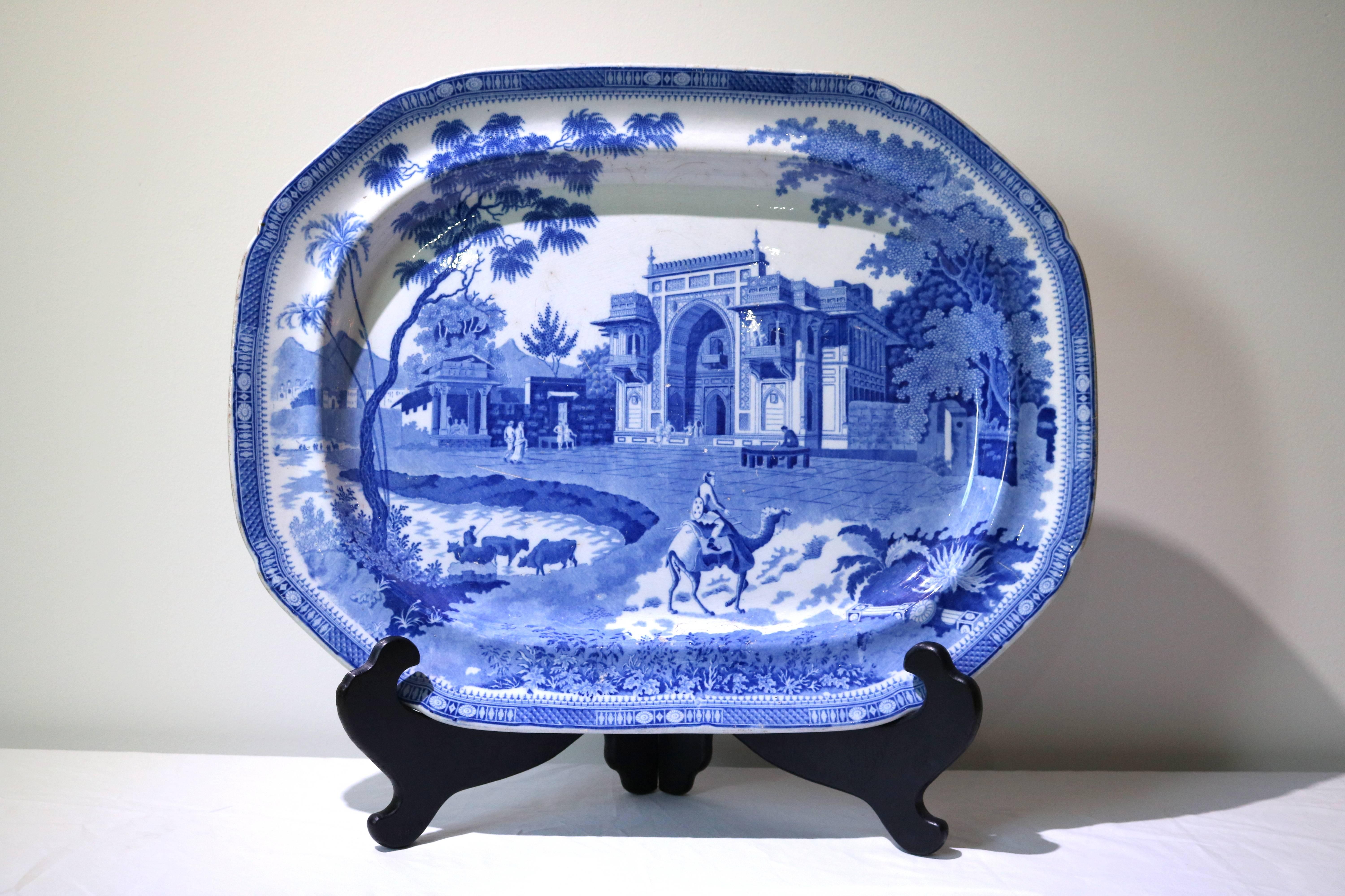 This large-scale serving platter dates from the 1840s and was purchased in London. The blue transfer-ware pattern depicts an exotic Indian palace with palms, lakes, camels, cows and attendants.

Please feel free to contact us directly for a