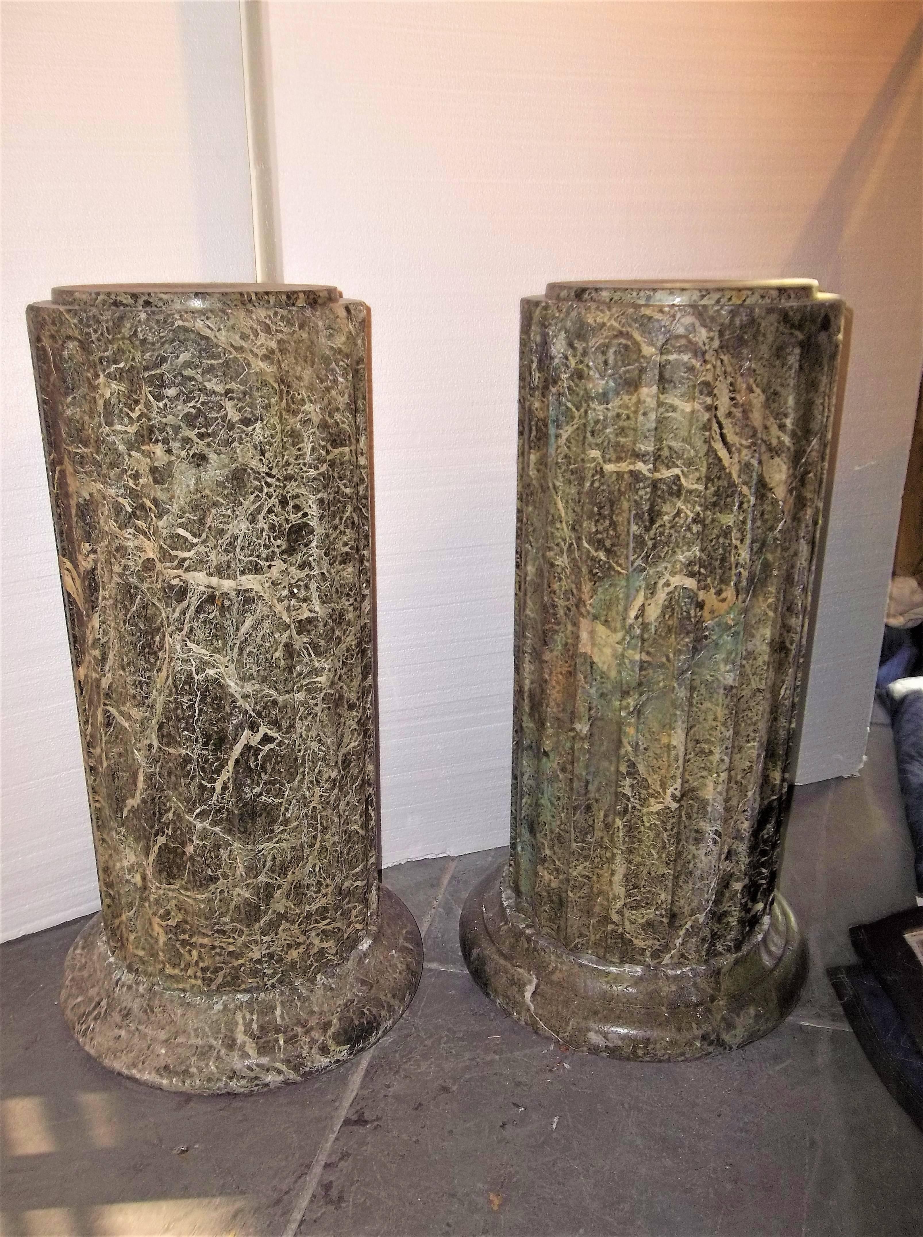 Pair of 18th century origin, each consisting of three parts; circular base fluted shaft and lid.
The green (Verde antico or Latin for ancient green) marble of heavily veined aggregate. The bases and shafts hand hewn. Each lid probably later with