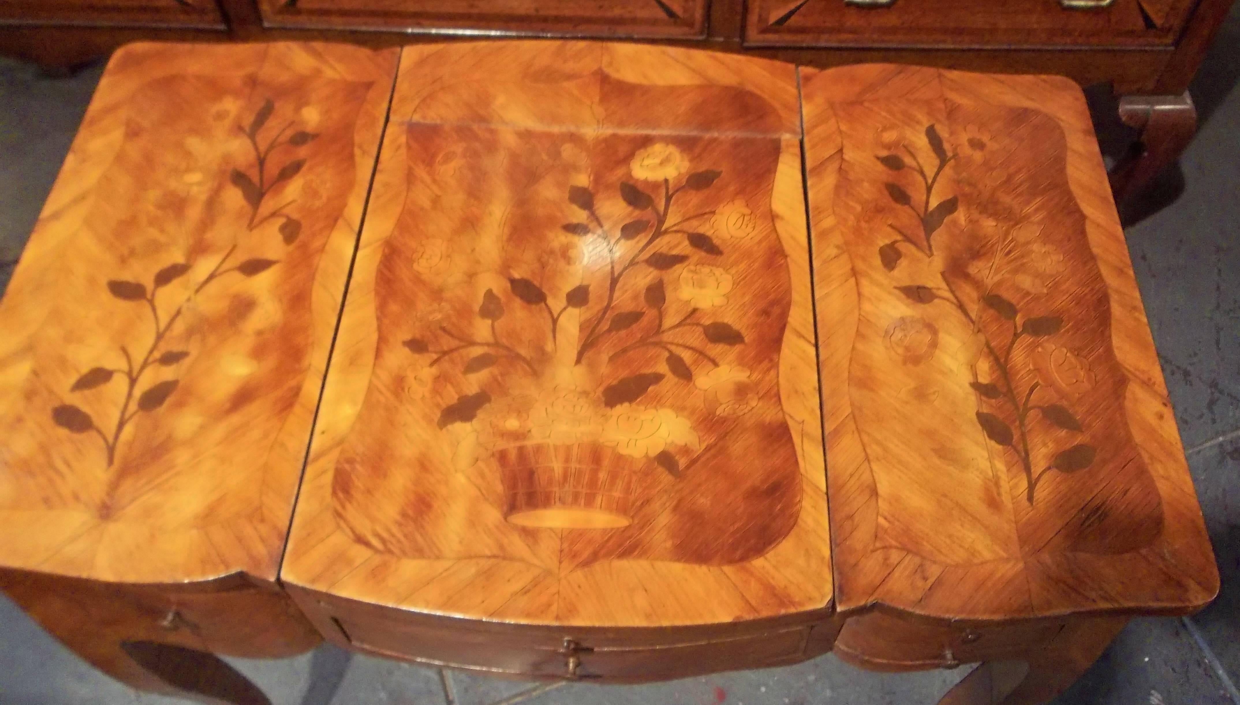 Originally a tri-fold poydreuse or vanity but these days almost always a bedside table or lamp table. Tulipwood with the red and light brown fading that distinguishes this wood as it ages. Nice overall cognac color. Each top panel in stained floral