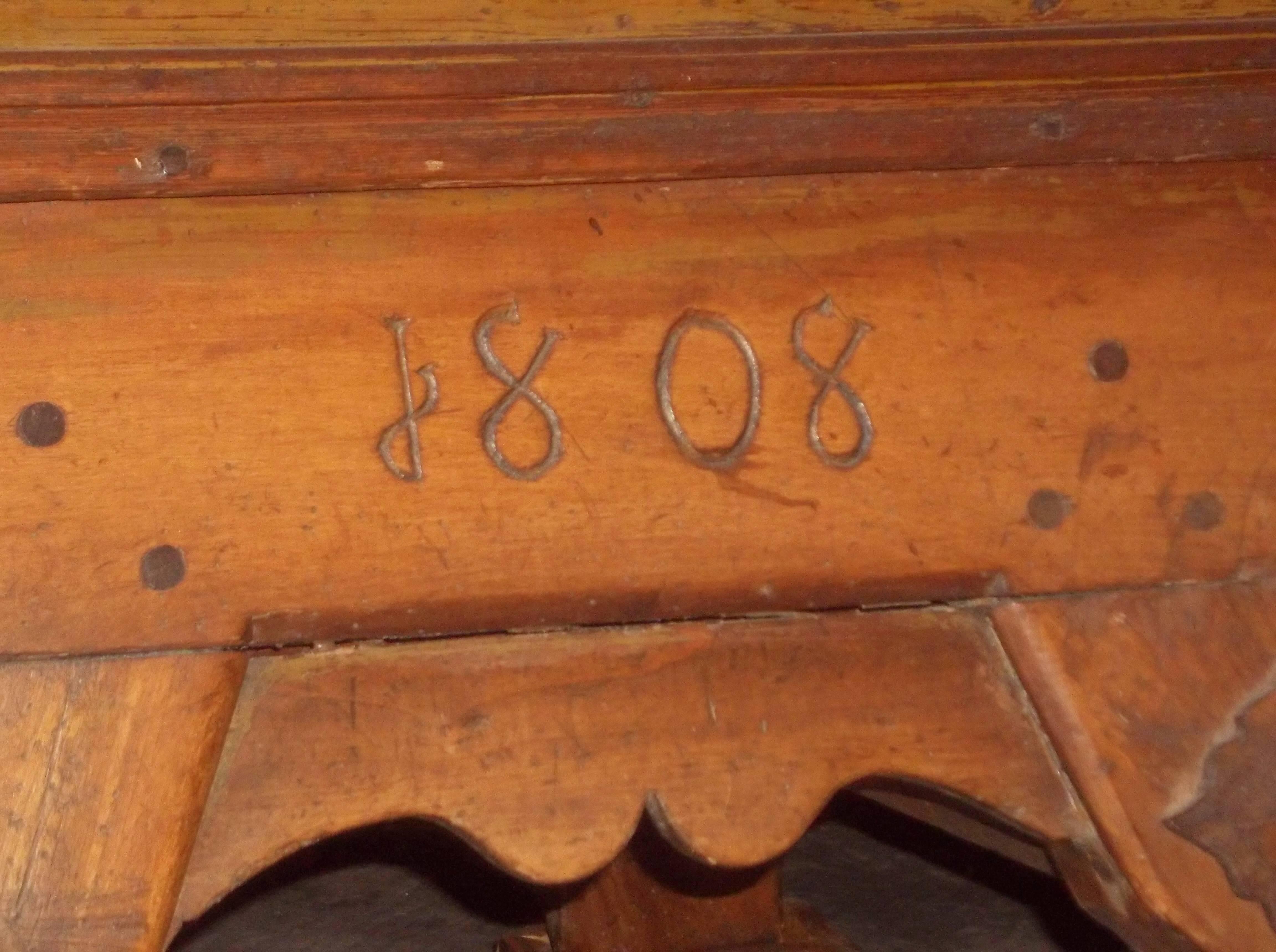  Of mixed woods (maple, fruitwood, pine, oak). In two distinct pieces, a heavy maple top and the base. The top slides left to right and back to reveal a secret depository over an obvious working drawer. Peg construction.

Fine scratches and light