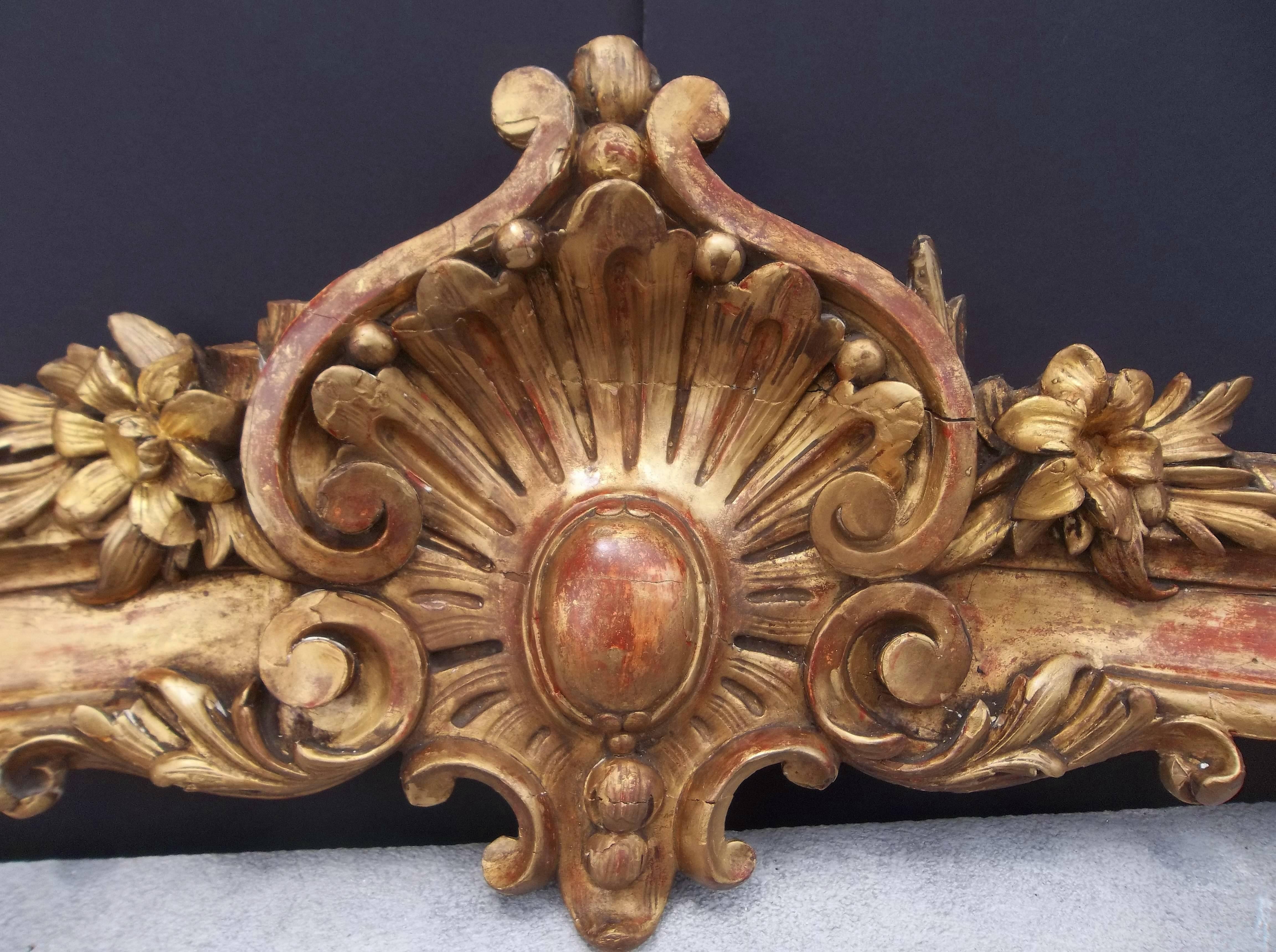 Possibly part of a window valence. 

Overall highly decorative but with numerous chips, losses with some re-gilt, some in-painting and other touchups. Filled crack across the central shell. Red bole and some white underbase gesso showing