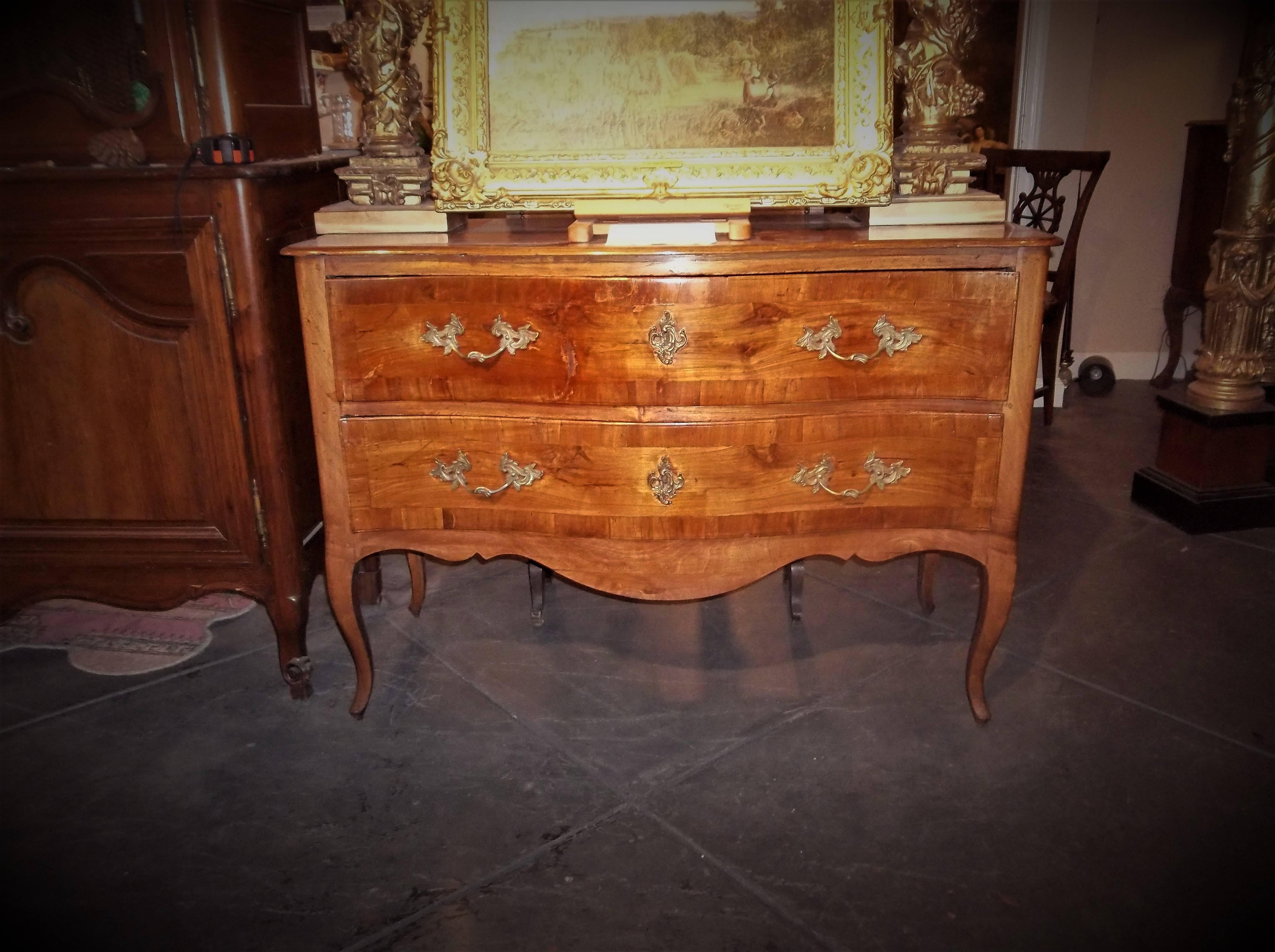 A classically simple serpentine shaped chest of walnut and fruitwood. Rich color and patina, fine polished finish. The inside papers have been lacquered to preserve and reflect the progress of time. Peg construction. No working key. 
Slight wobble