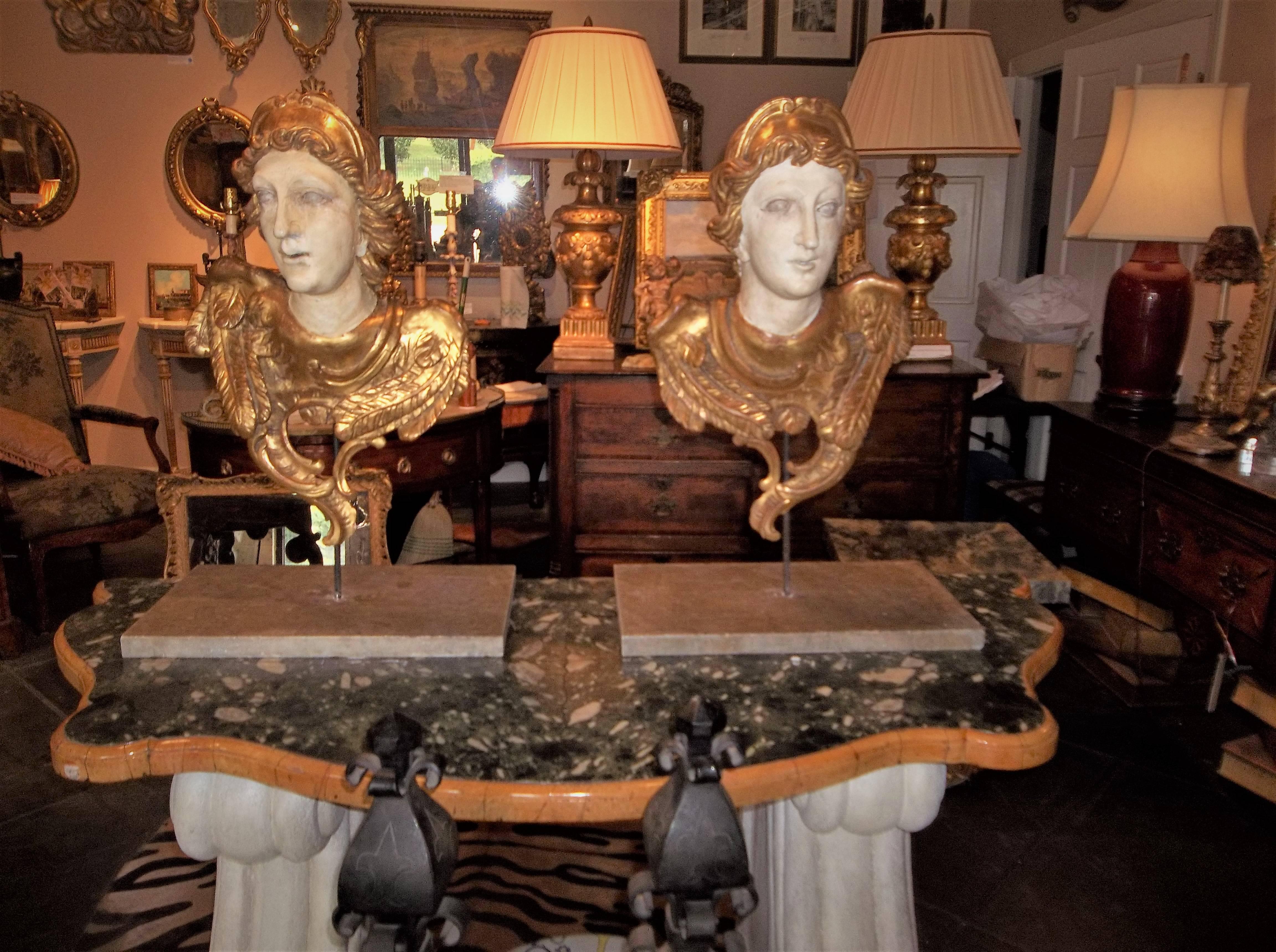 Possibly angels from an altar (note the feathers) or the usual cherubs or putti.
Probably early 19th century, Italy or France. 

Crisply carved with gilt highlights. On iron rods and heavy marble bases. Cannot tip over, very sturdy. Can be wall hung