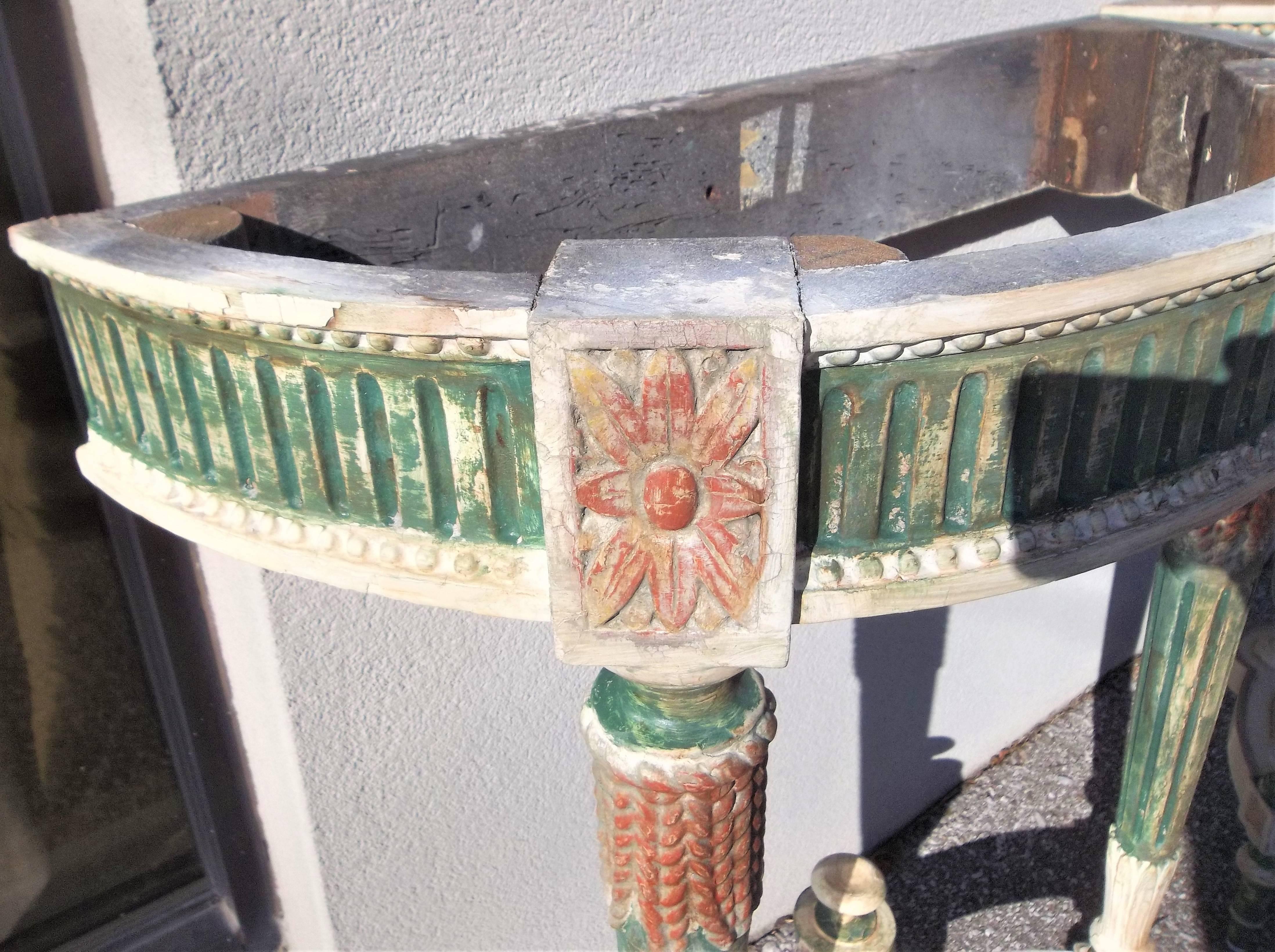 With well veined beveled marble tops in the color of orange sherbet. Each colorful console with intentional distressed paint , French green against cream . Gilt highlighted areas with Venetian red bole bleeding through. 

Good sturdy condition. 