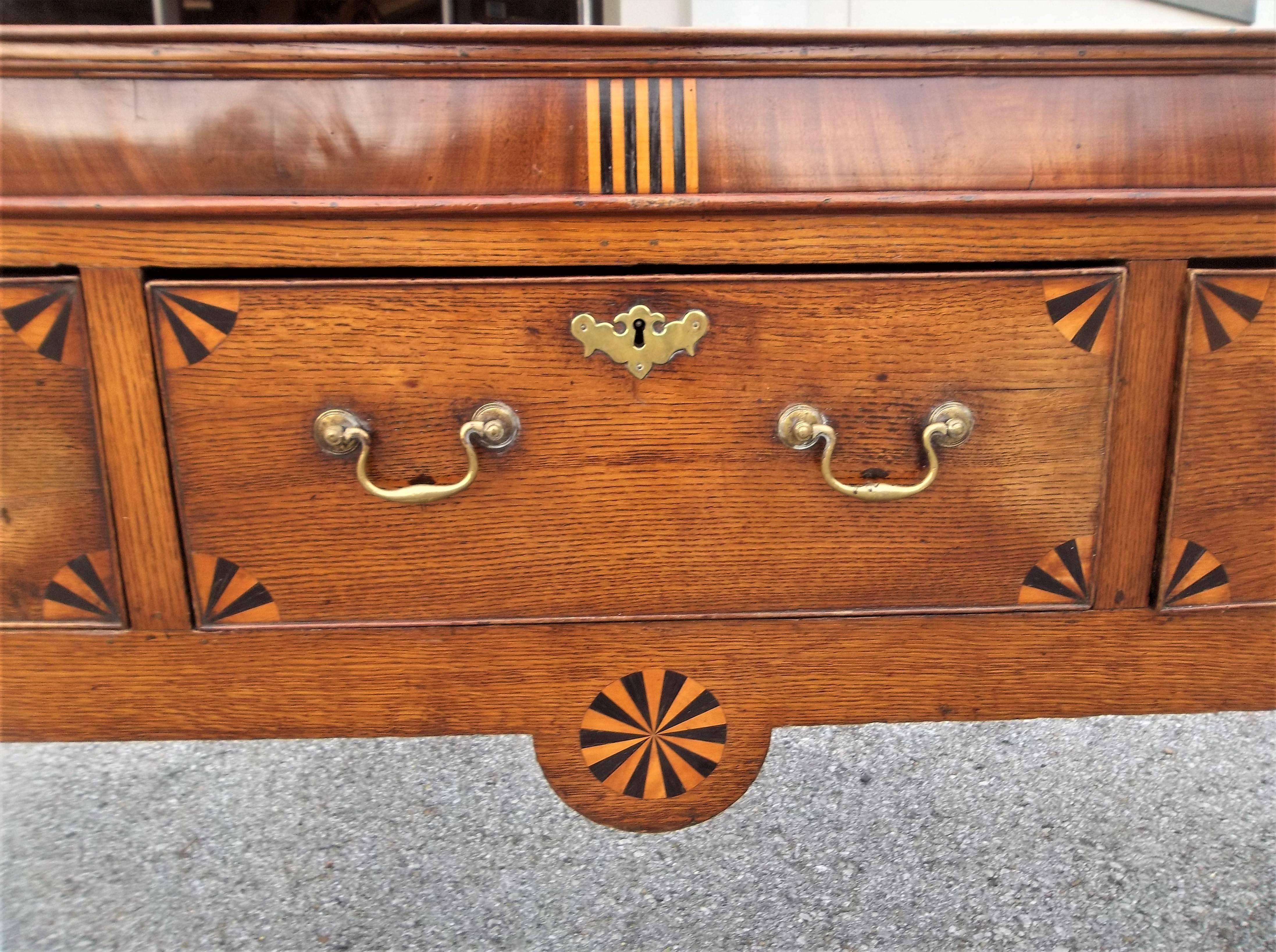 With inlaid mahogany banding and fan inlaid drawers. Tall for a dresser base, more of sideboard height. Hand cut dovetail to each drawer .Nice warm cognac color. Typical use stains to the top. Apparently original hardware. Solid boards (possibly