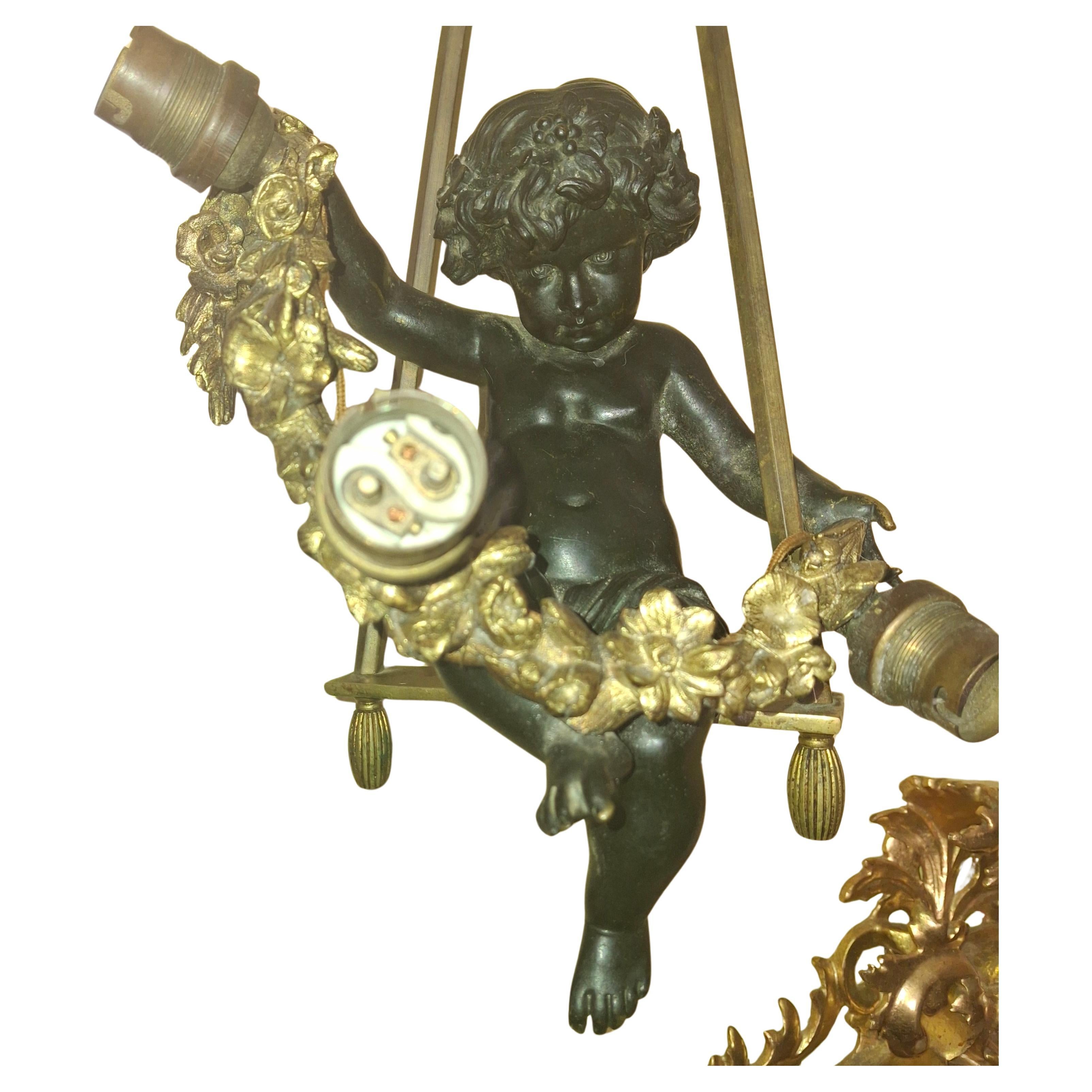Grand Chérubin en bronze patiné et doré sur sa balançoire avec guirlande Chandelier/ Pendentif à 3 Lumières du 19ème siècle. Des pièces moulées très détaillées et de très haute qualité. Rarement trouvés, les chérubins français en bronze doré et