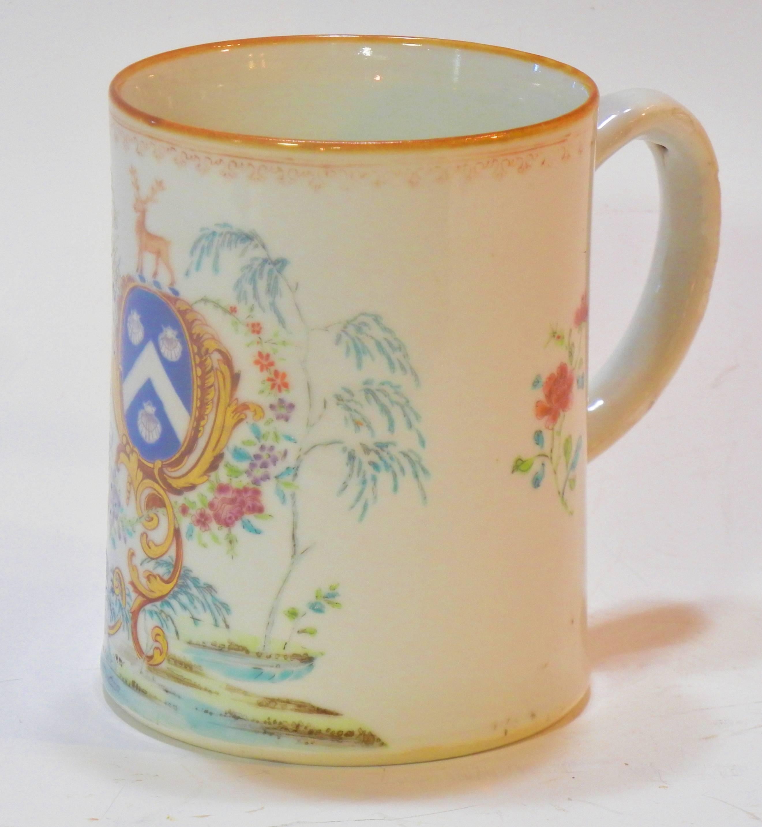 This hand-painted famille-rose and gold porcelain tankard has a Western armorial shield with three scallop shells of Saint-James around a white chevron on a blue field beneath a stag. The shield is mounted on and held erect by an elaborate gold