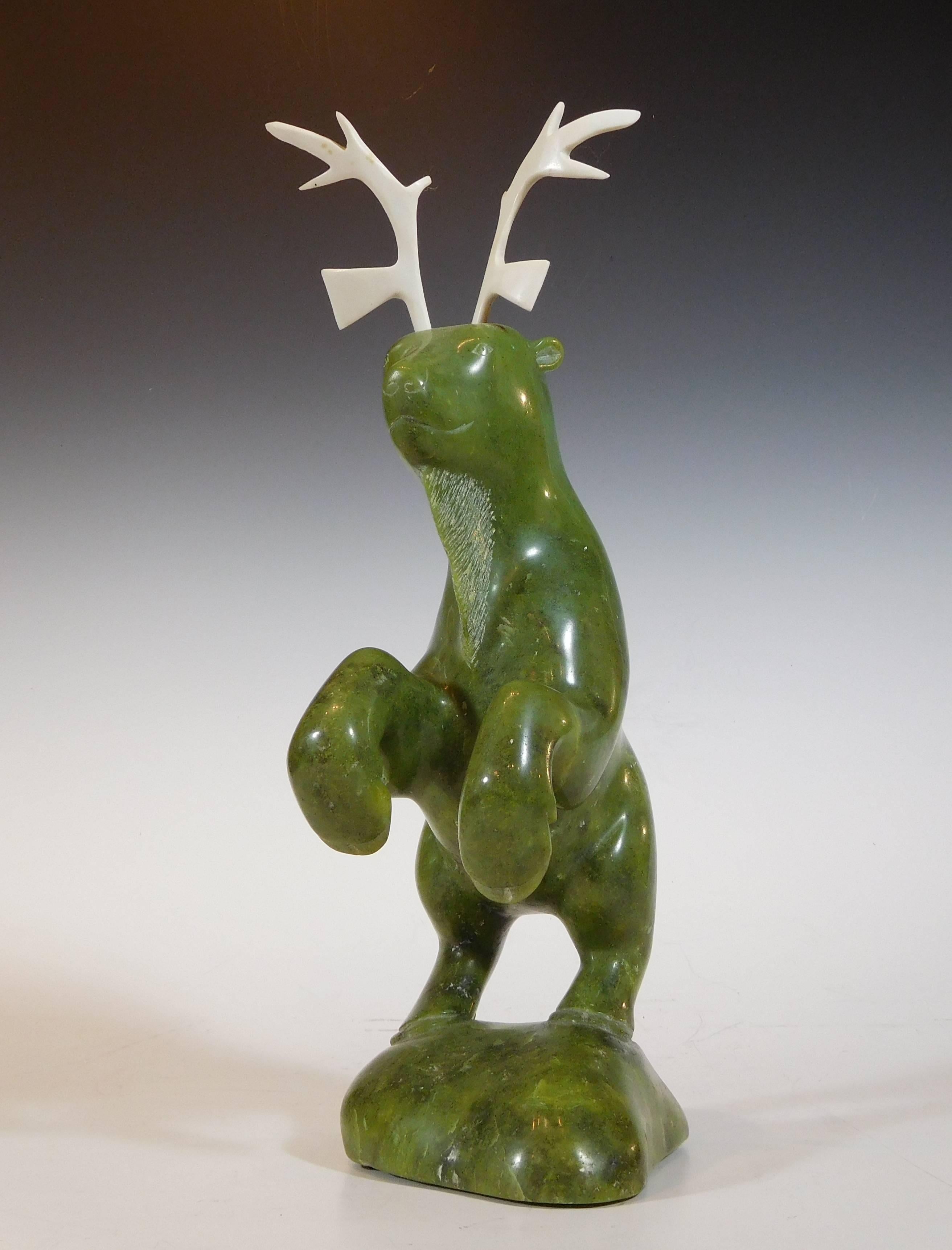Inuit master carving of a dancing caribou in noble serpentine and caribou bone by Pitsiula Michael, signed and dated 1986 (as incised on the base), of Lake Harbour, Baffin Island, Nunavut, Canada. The Canadian Government official authentication tag