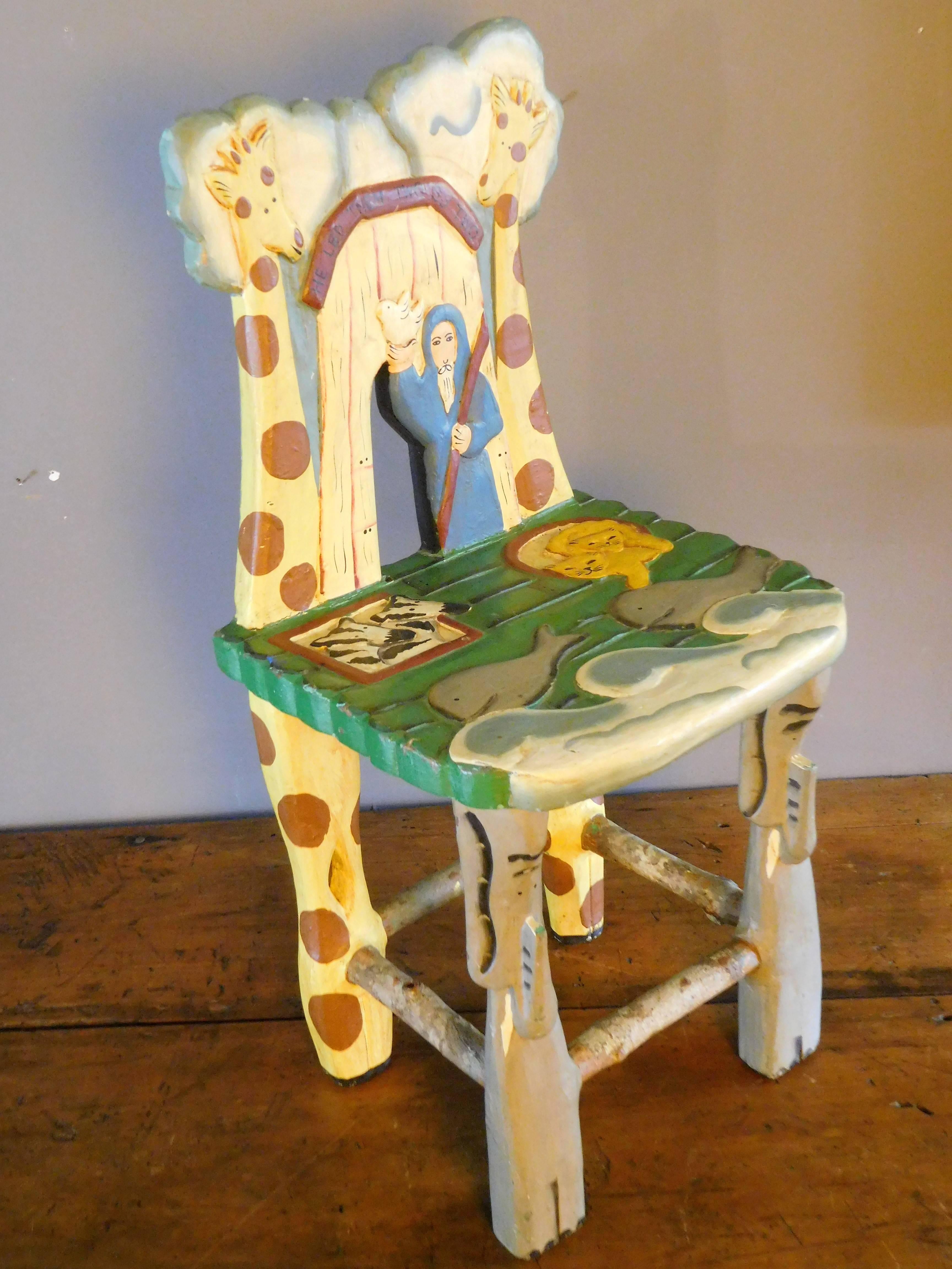 This toddler's chair is hand-carved and hand-painted. It depicts the Biblical story of Noah's Ark. The artist shows rain clouds over the entrance to the ark where Noah stands with a dove, as he 