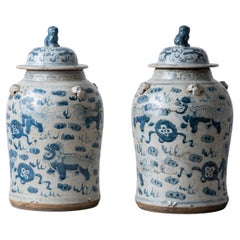 Pair of Chinese Blue and White Glazed Jars with Foo Dog Lid Finials