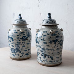 Pair of Chinese Blue and White Glazed Jars with Foo Dog Lid Finials