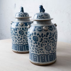 Pair of Chinese Blue and White Glazed Jars With Foo Dog Finials