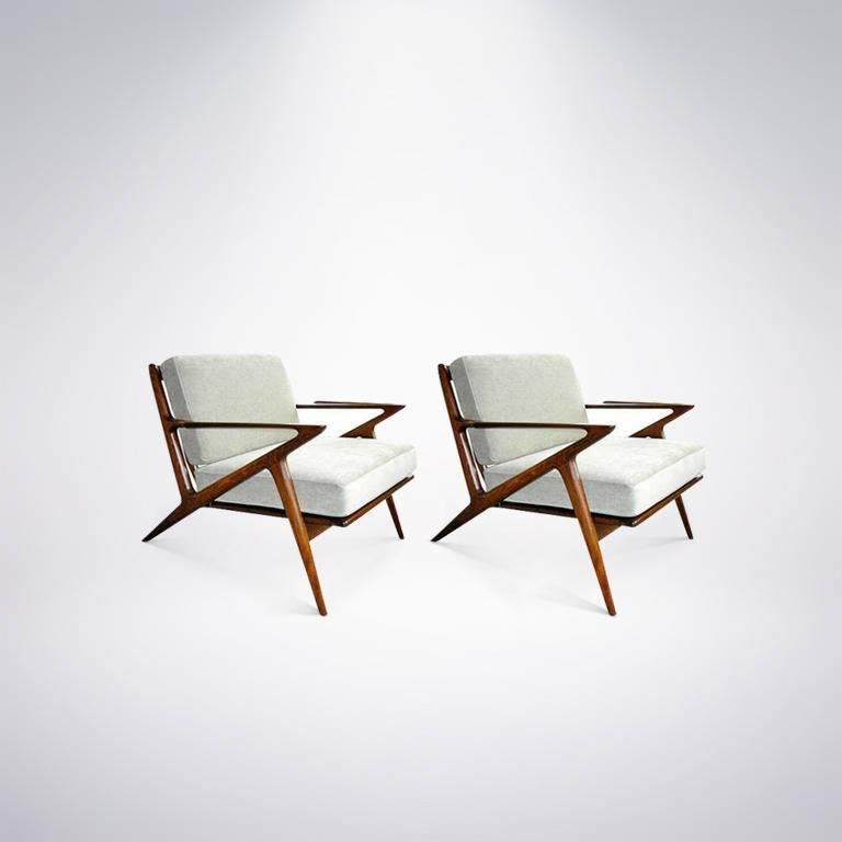 Classic pair of Danish modern lounge chairs design by Poul Jensen for Selig. Sculptural frames newly refinished in medium walnut; brand new cushions upholstered beige / light grey velvet.