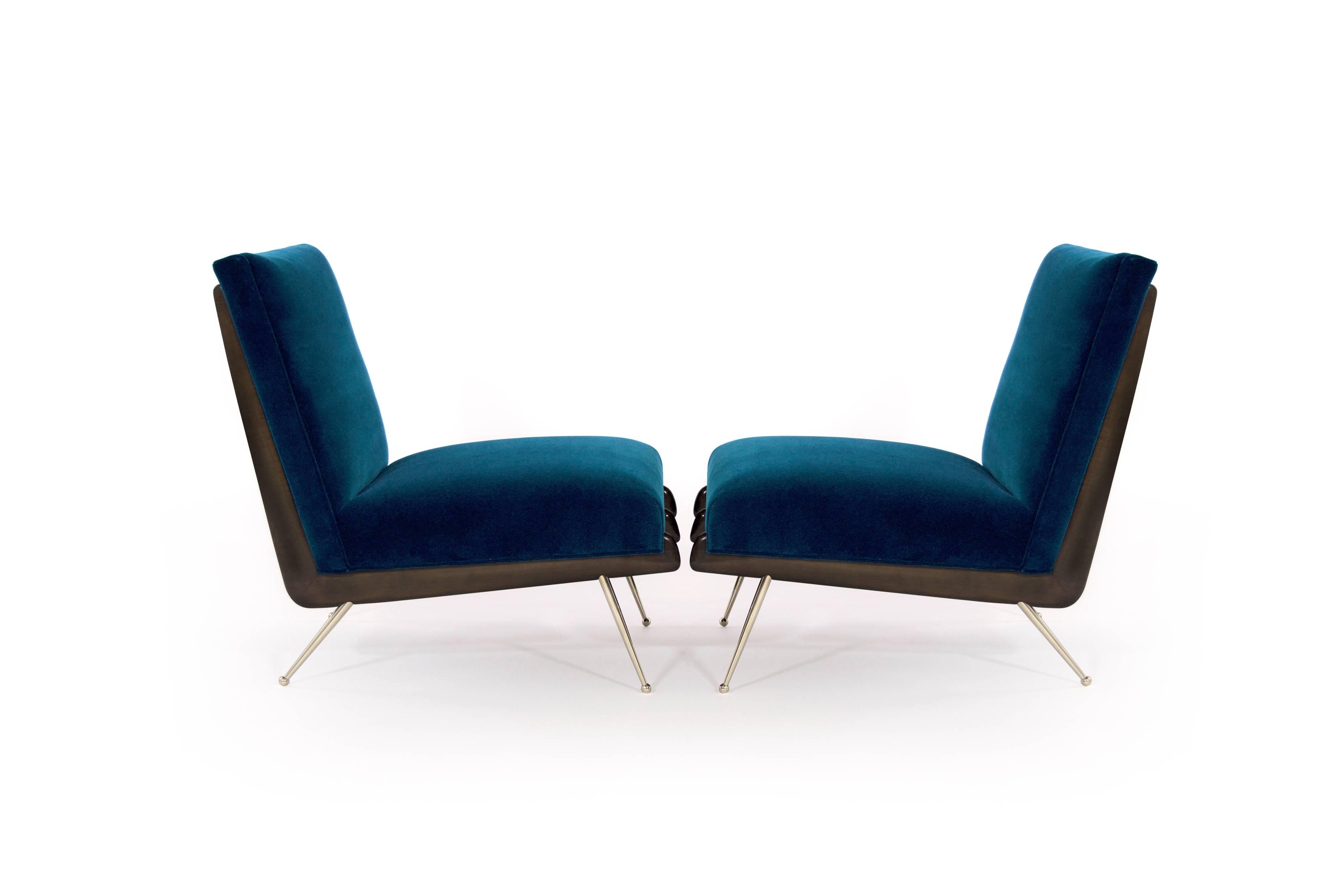 Stunning and rare pair of lounge chairs in the style of Gio Ponti, circa 1950s.

Boomerang shaped walnut frames fully restored, newly upholstered in Holly Hunt aqua cotton velvet. Thin tapered brass legs newly polished.