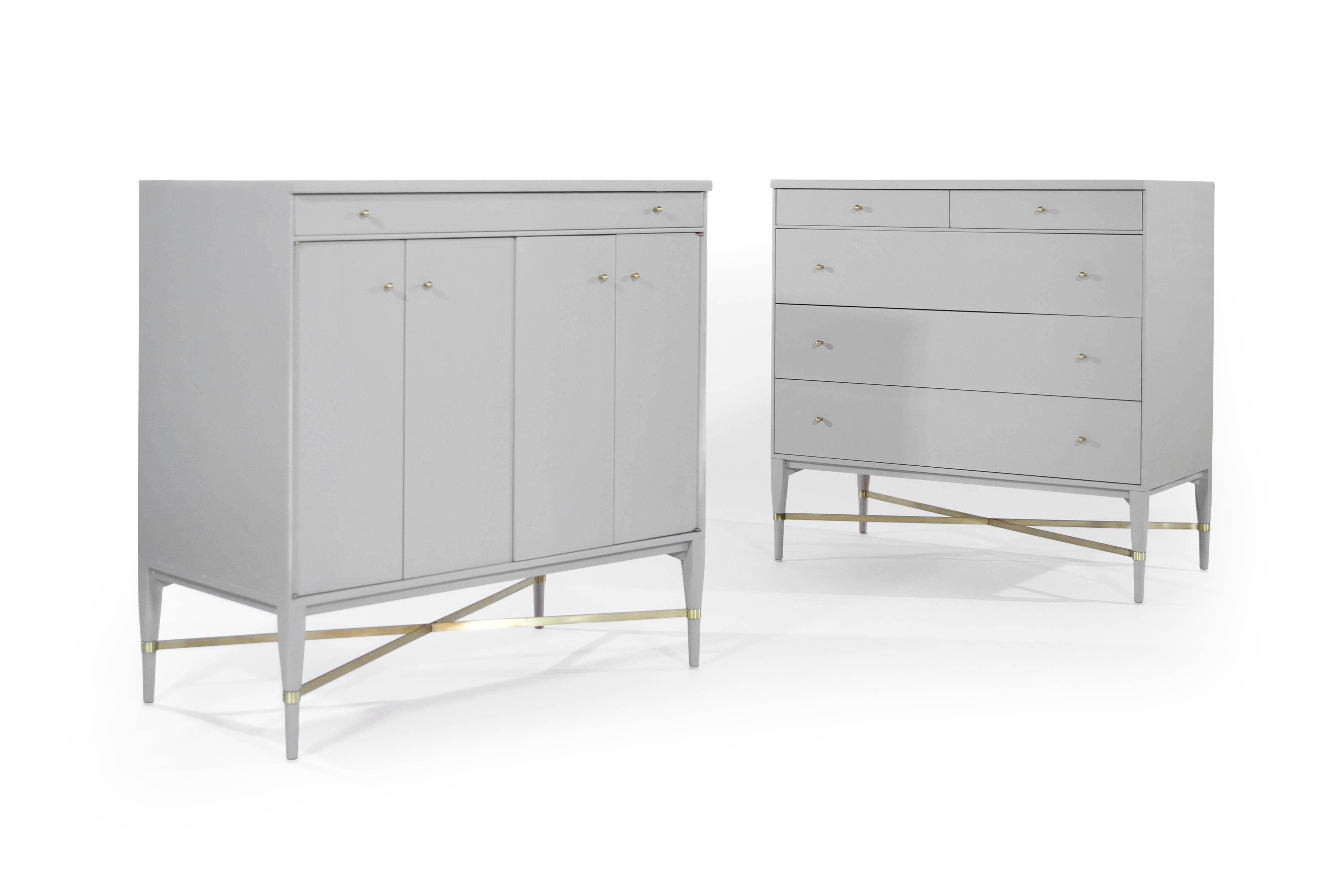 Pair of complimenting bedside tables by iconic furniture designer Paul McCobb. 

Exquisitely redone in light grey, one features a set of 5 drawers, the other bi-fold doors which open to reveal a single shelf.