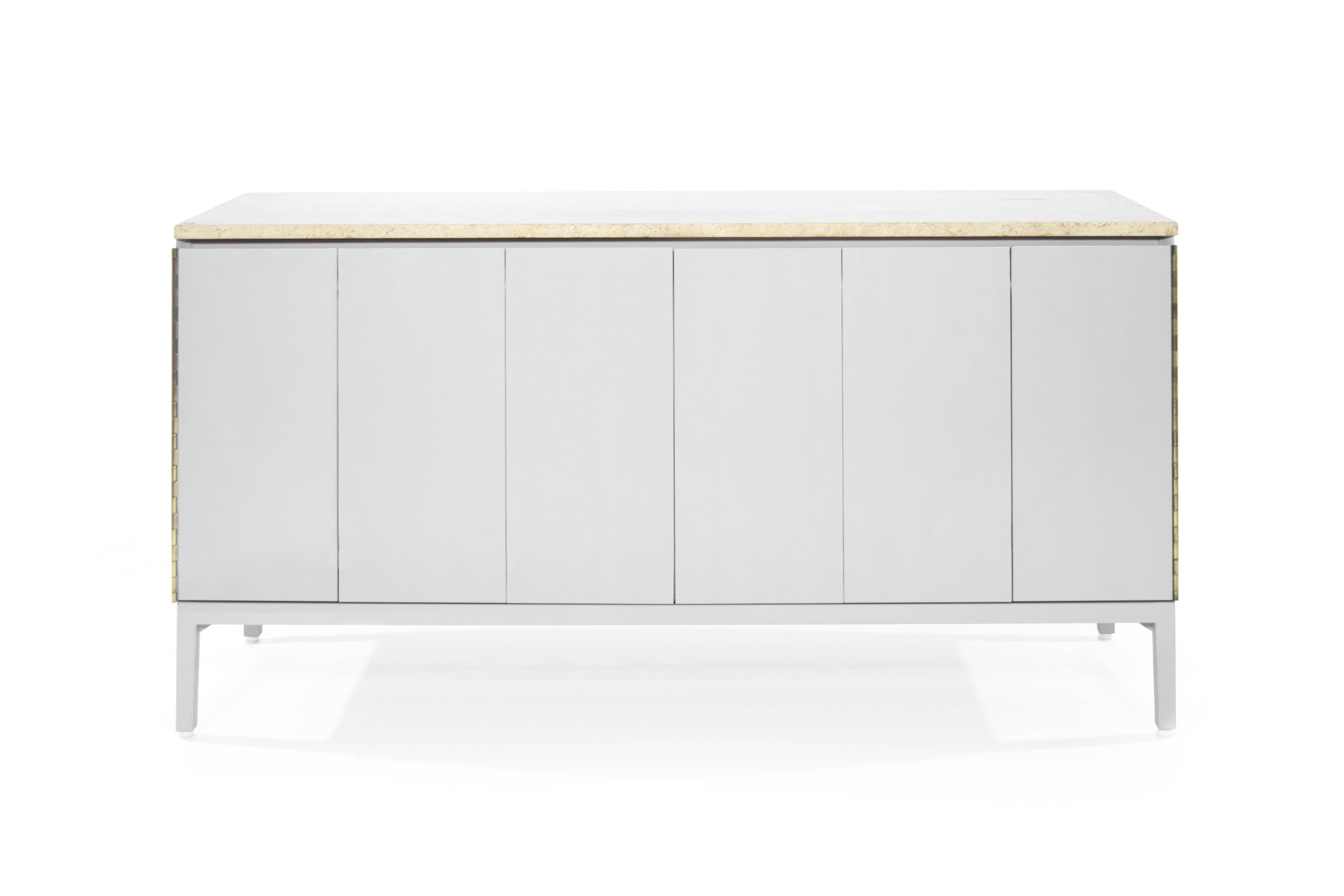 A dresser by iconic furniture designer Paul McCobb. Exquisitely redone in light grey, this dresser features tri-fold doors which open up to reveal eight drawers, providing ample storage space. Original travertine top has been newly polished.