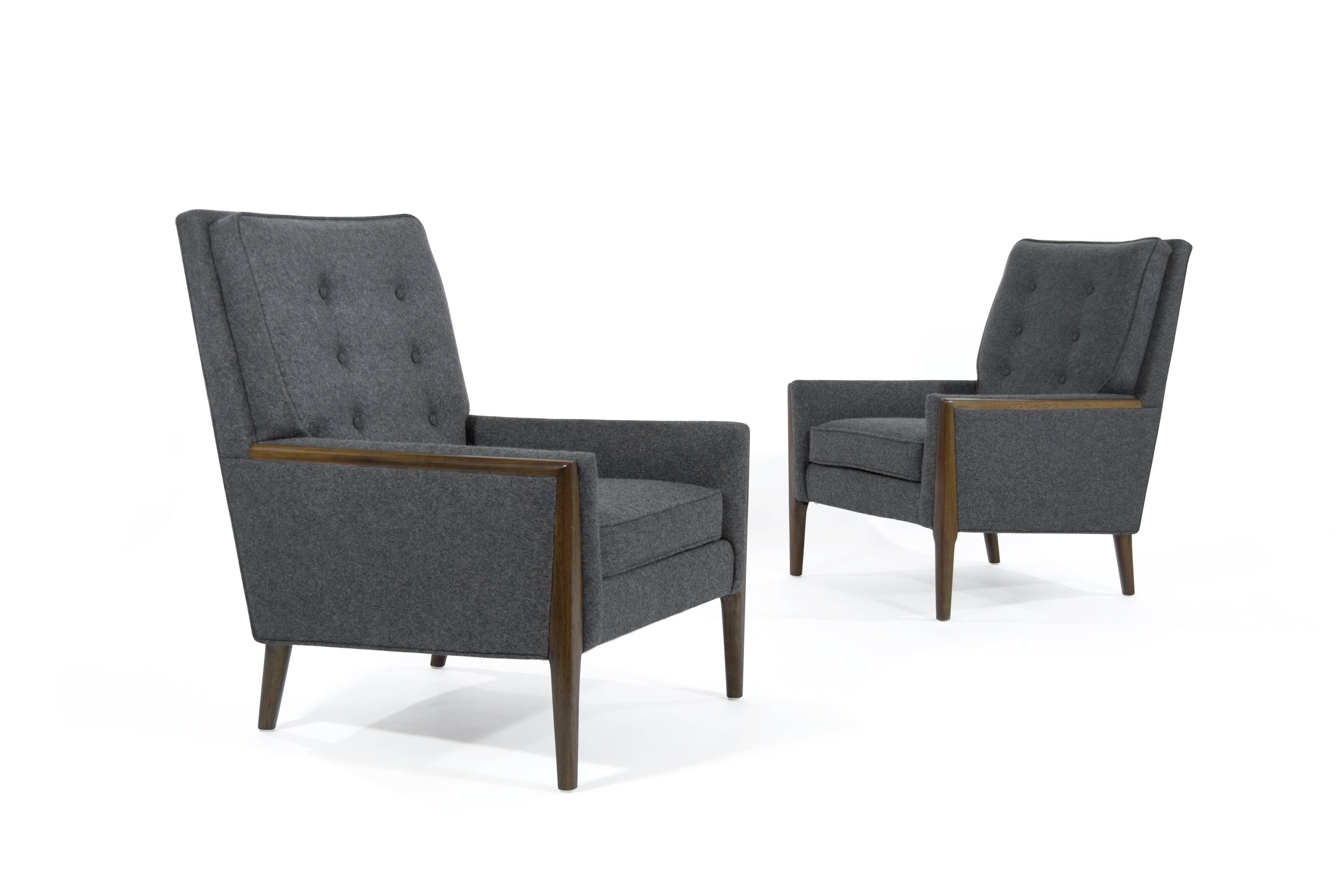 Comfortable pair of high back lounge chairs in the style of T.H. Robsjohn-Gibbings. Walnut trim fully restored, newly upholstered in grey wool.
