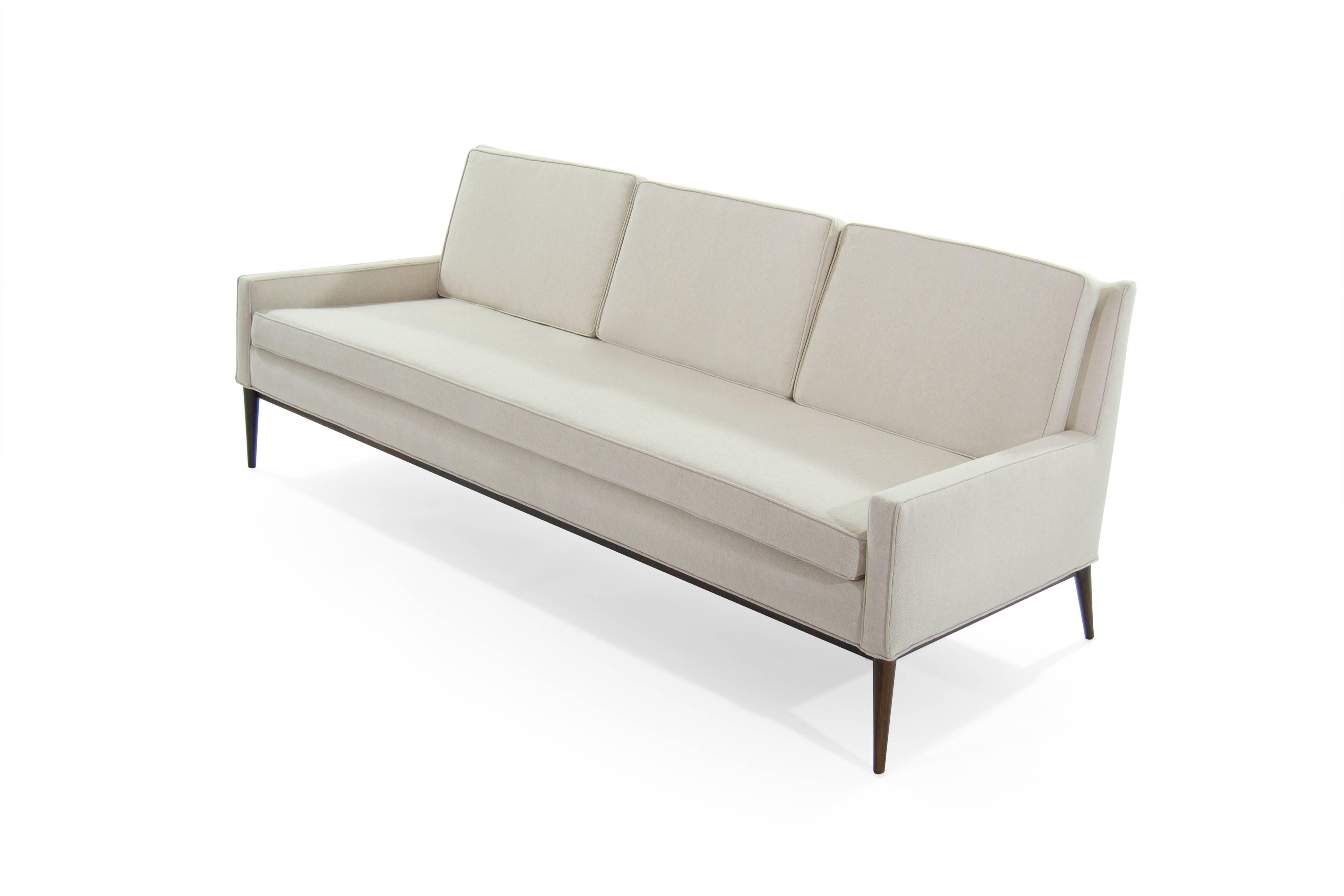 Sofa designed by Paul McCobb for Directional, model #1307, circa 1950s.

Newly upholstered in linen, walnut base fully restored. Listing is for single sofa.

          