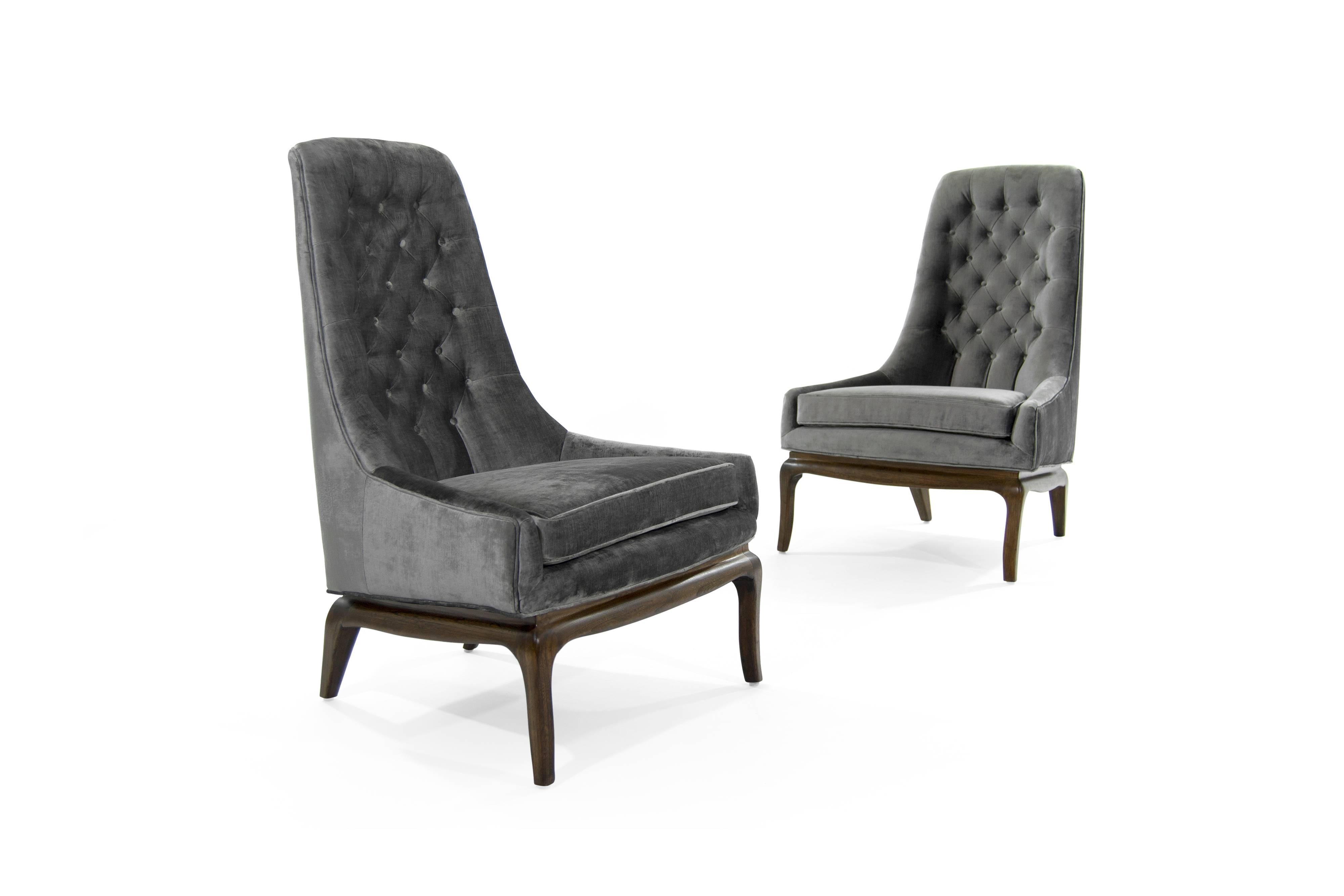 Exquisite and elegant pair of tufted high back lounge chairs on walnut sabre leg walnut bases, in the style of T.H. Robsjohn-Gibbings. Walnut fully restored, newly reupholstered in a shiny grey velvet.