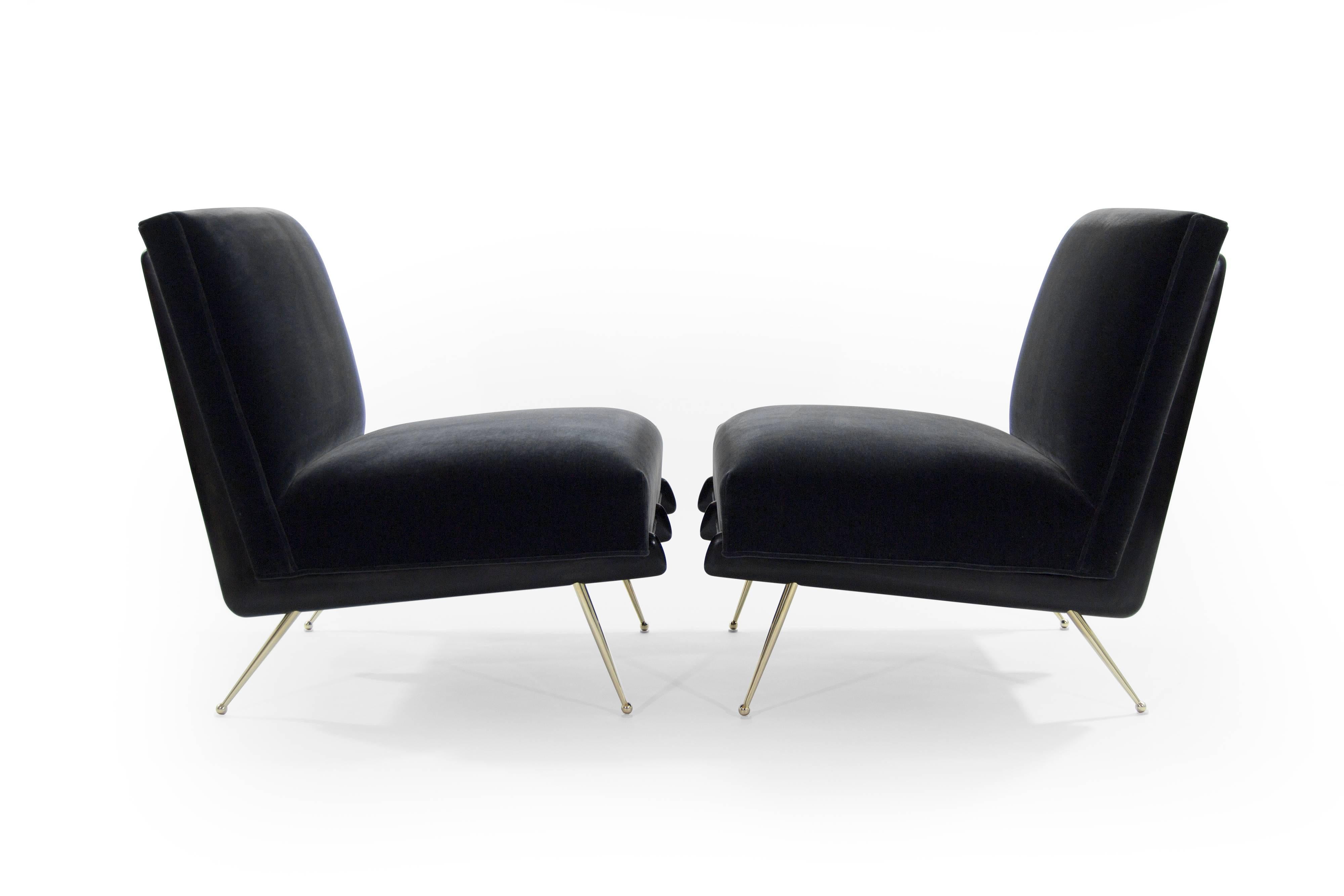 A phenomenal pair of lounge chairs in the style of Italian designer Gio Ponti, circa 1950s.

Boomerang shaped walnut frames fully restored to their original ebonized finish, newly upholstered in charcoal mohair. Thin tapered brass legs newly