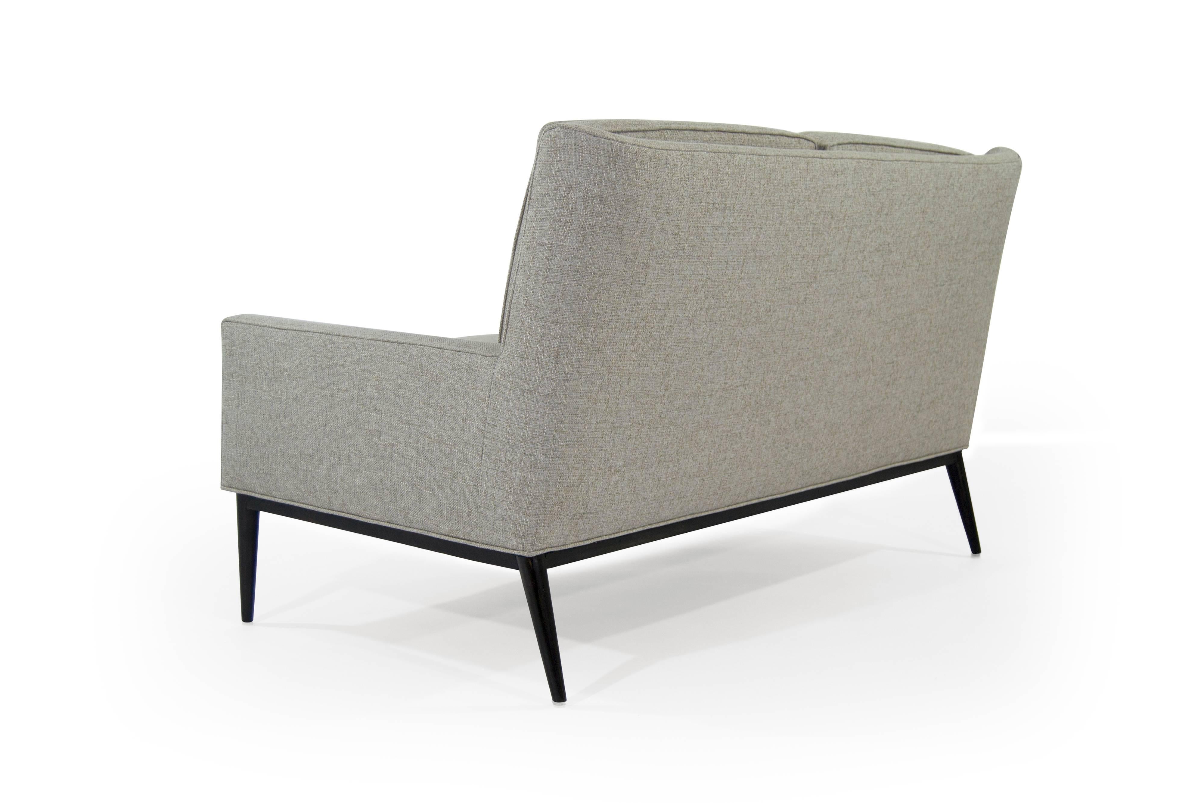 Rare loveseat designed by Paul McCobb for Directional, circa 1950s. Newly upholstered in taupe linen, base fully restored to its original espresso finish.