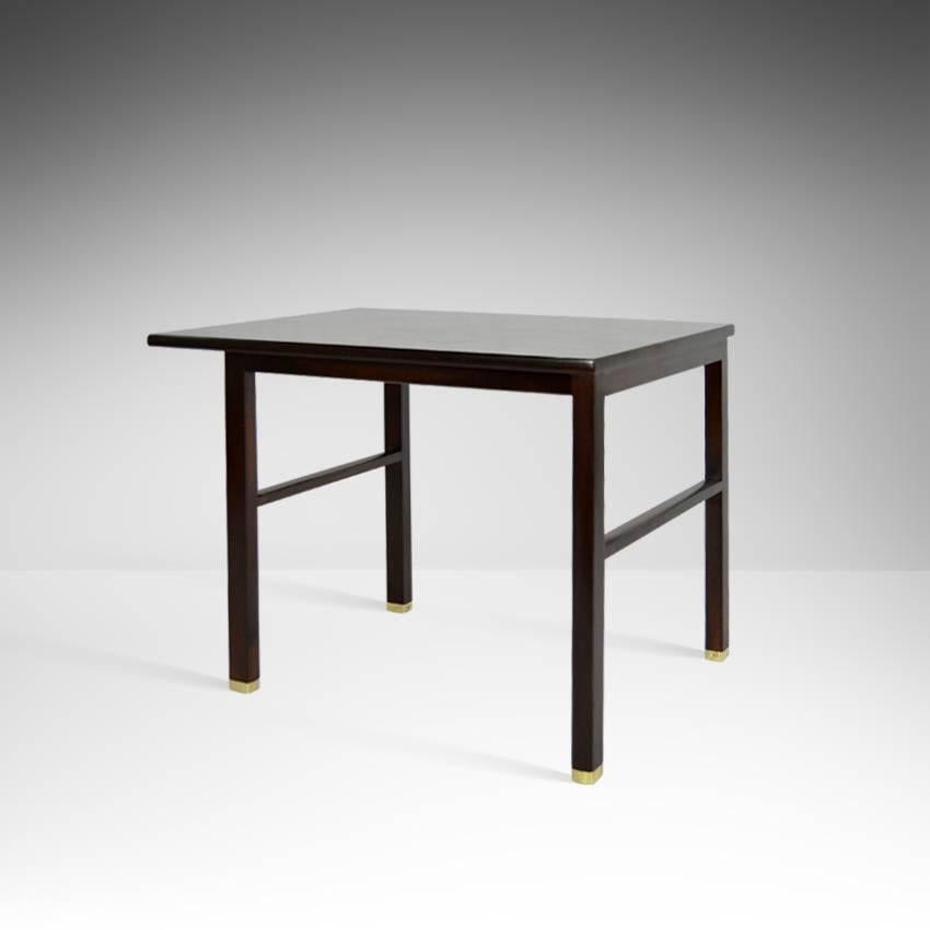 Cantilevered table by Edward Wormley for Dunbar in dark walnut with polished brass feet.
