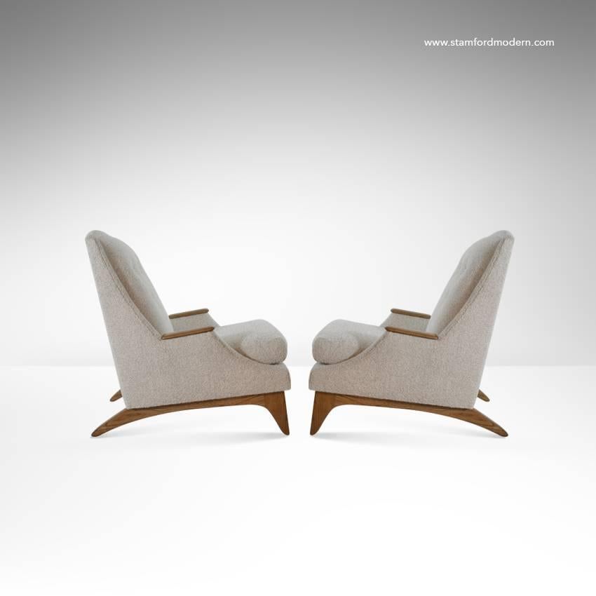Pair of high back lounge chairs newly upholstered in beige wool. Sculptural walnut bases and arm accents fully restored.
