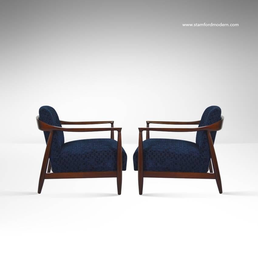 Pair of lounge chairs by Ib Kofod-Larsen, Denmark, circa 1950s. Sculptural walnut frames fully restored. Newly upholstered in blue chenille.